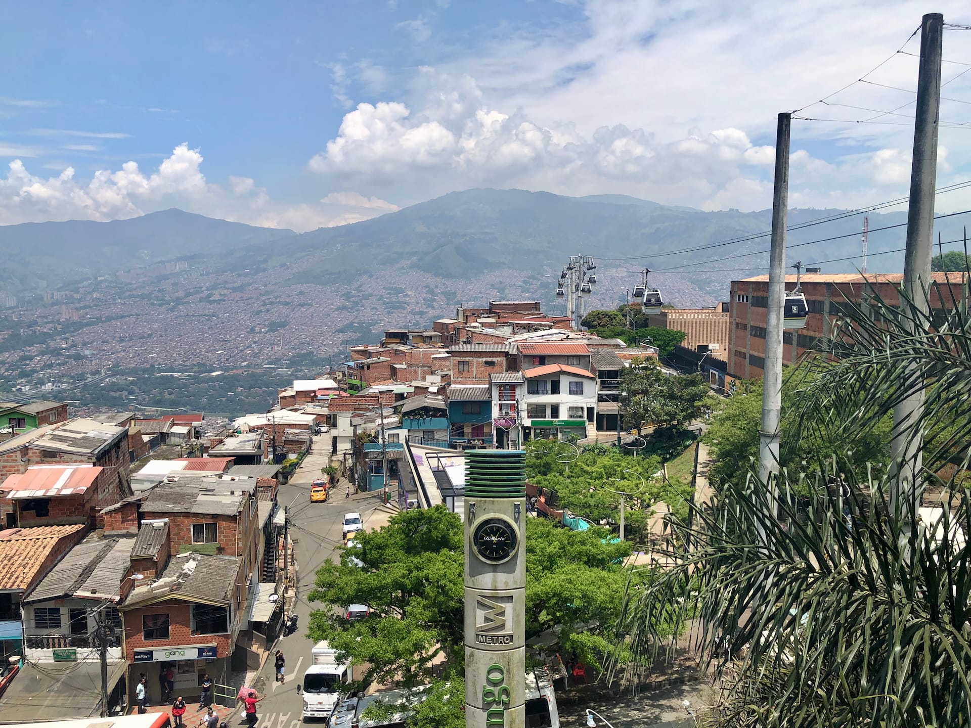 Medellín, Colombia Medellín hillside neighborhood with colorful houses and metro cable cars overlooking mountain landscape.