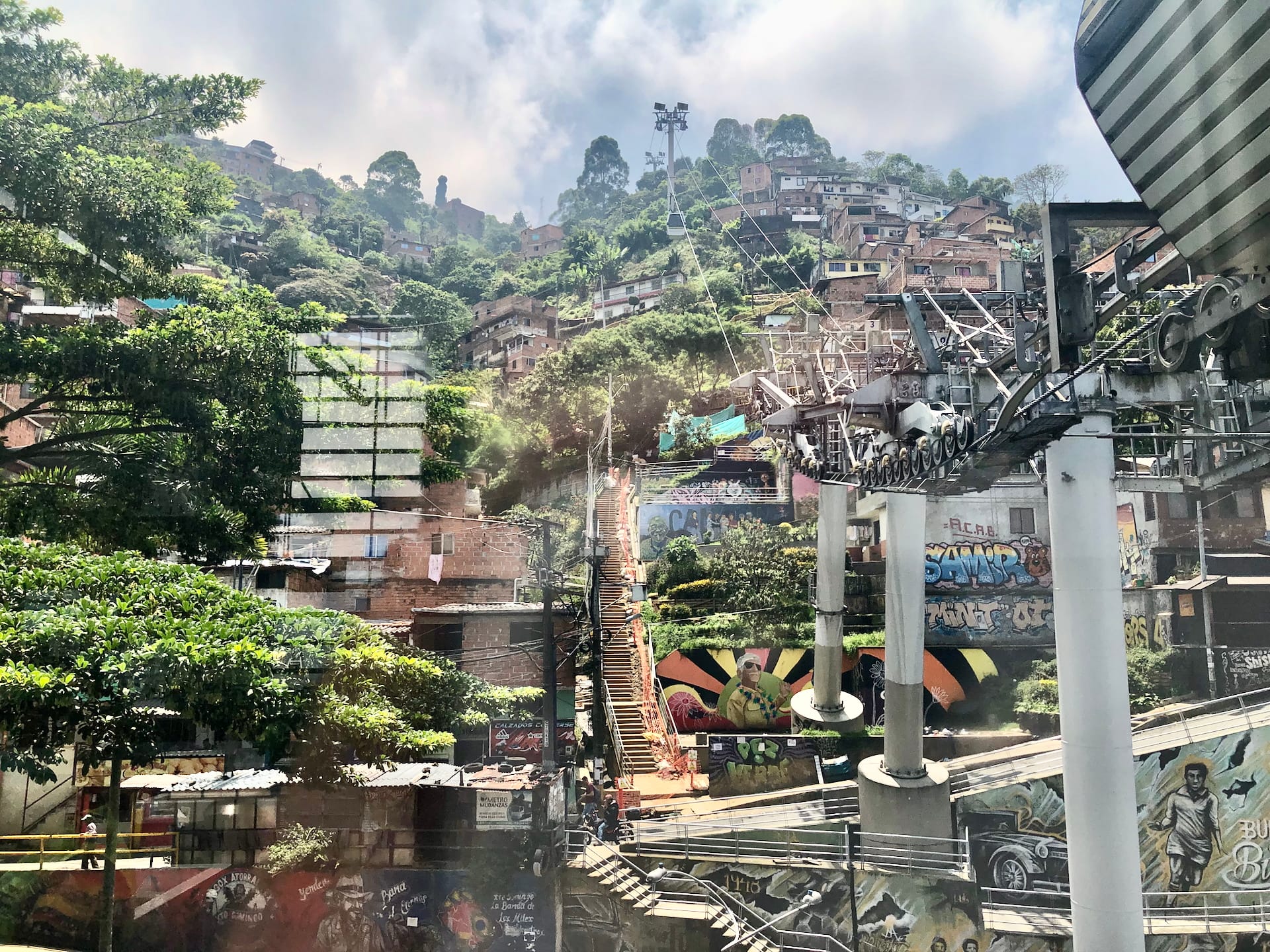 Medellín, Colombia Steep Medellín neighborhood with houses climbing mountainside, decorated with street art and connecting stairways.
