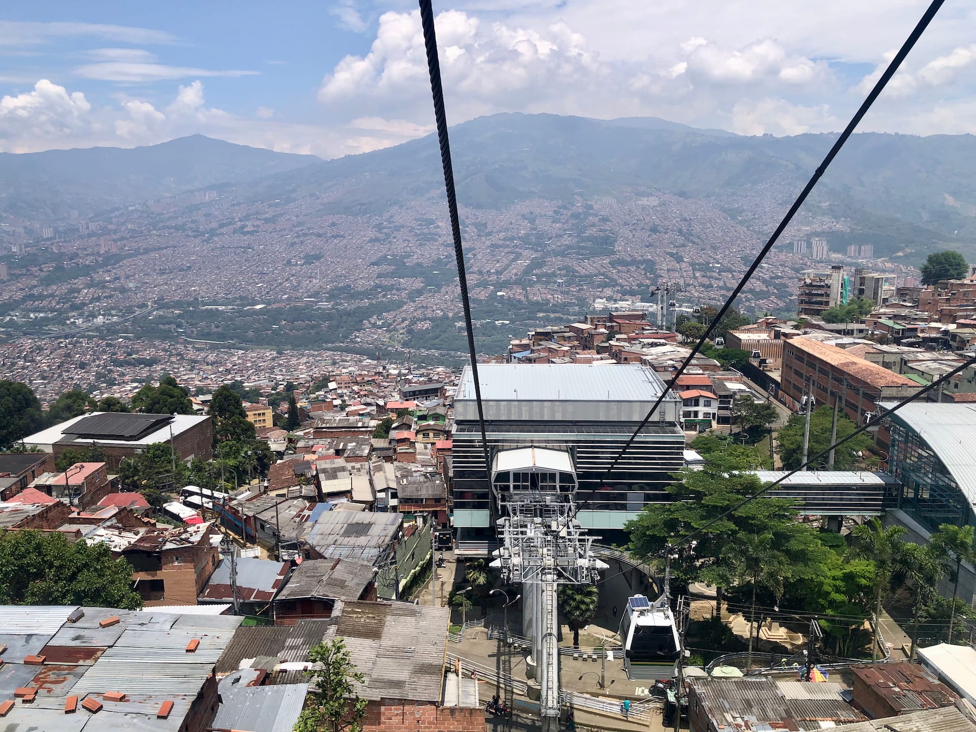 Medellín, Colombia Aerial view of Medellín's metro cable system connecting hillside communities with urban and mountain backdrop.