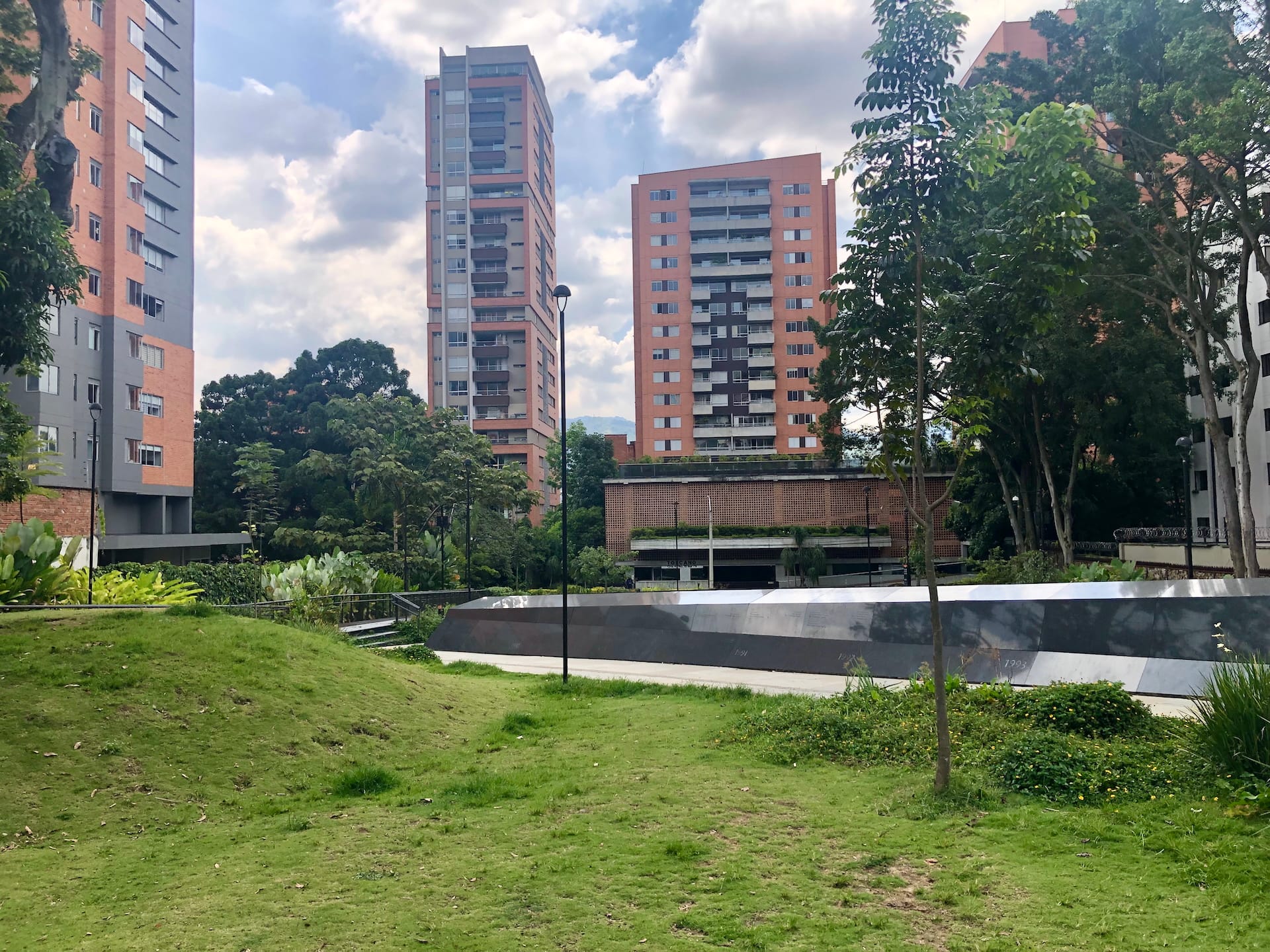 Medellín, Colombia Modern Medellín apartment towers surrounded by green trees and landscaped urban space.