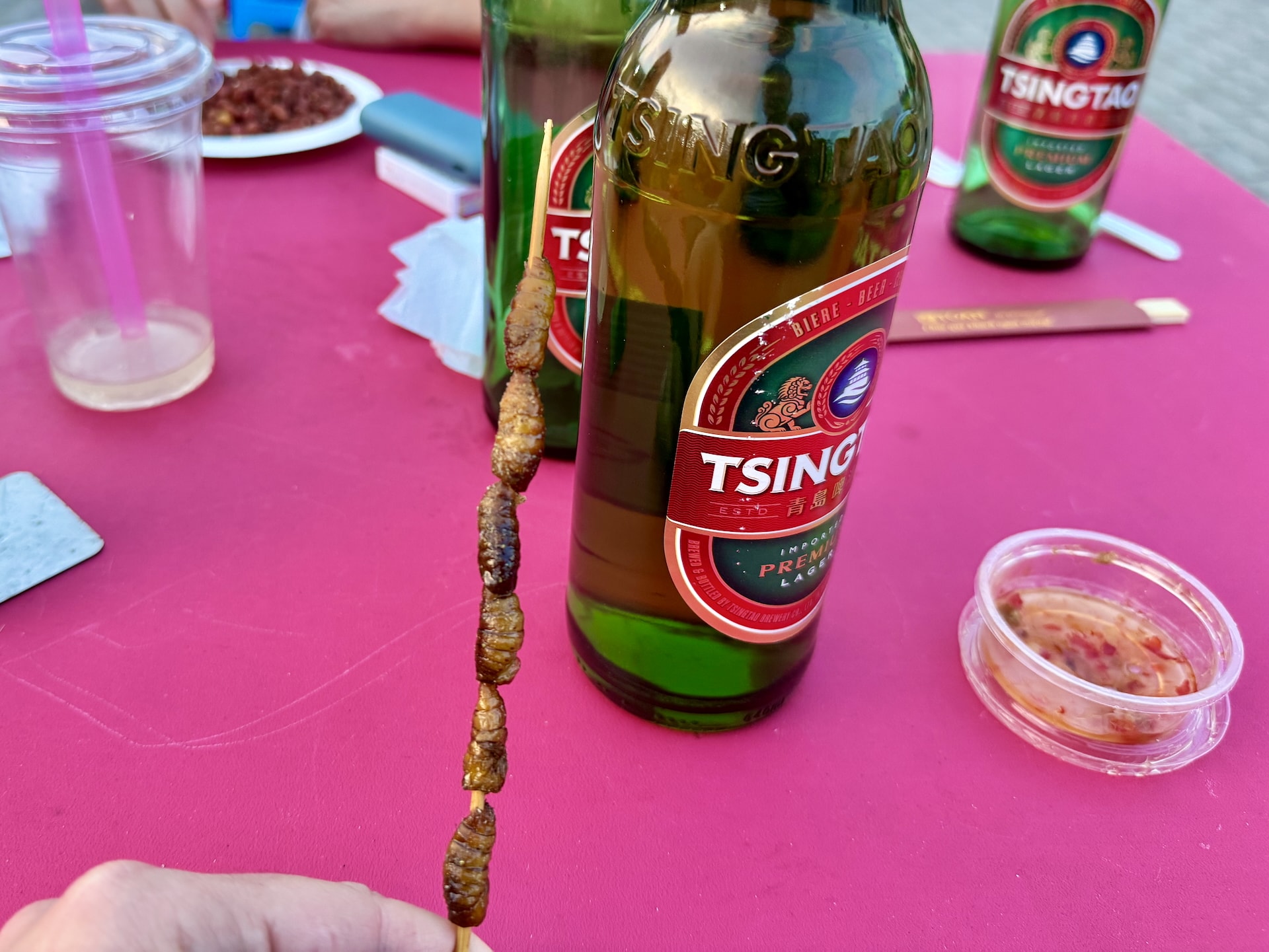 Budapest Chinatown Night Market Grilled silkworms on skewers paired with the Tsingtao beer that helped wash them down