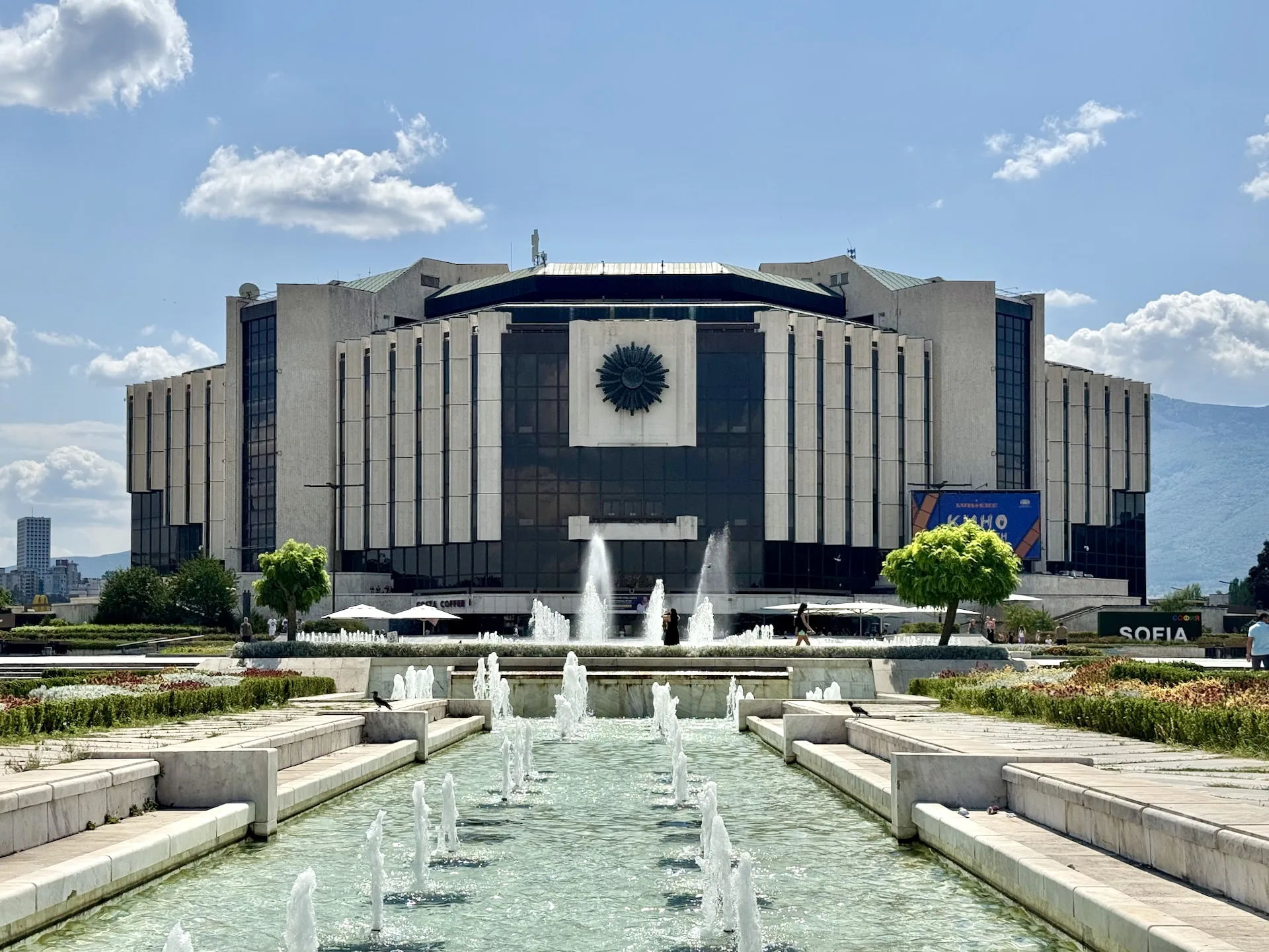 The imposing building of the NDK, with the fountain in its foreground.