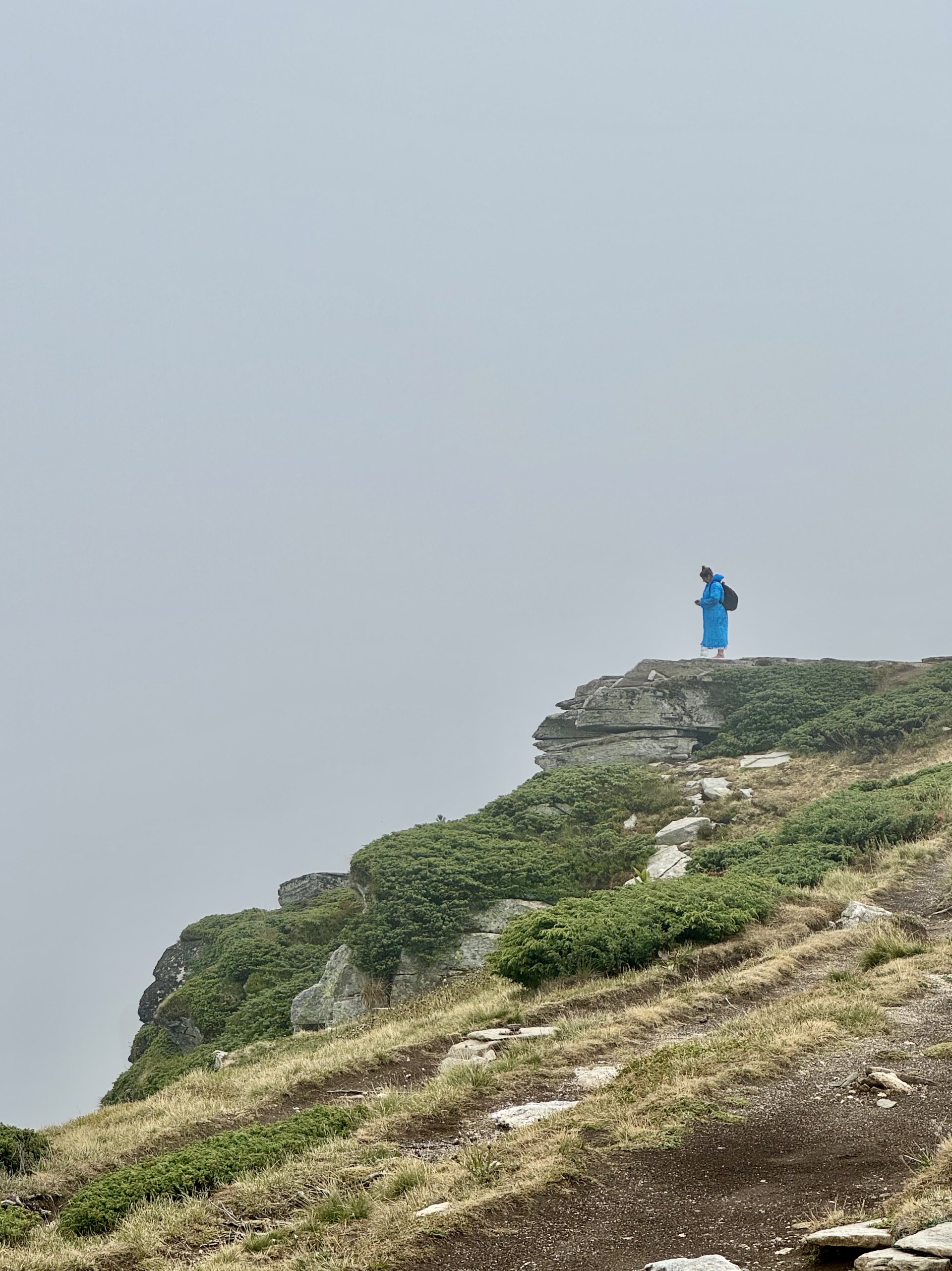 Seven Rila Lakes, Bulgaria A lone hiker at a lookout point in the fog