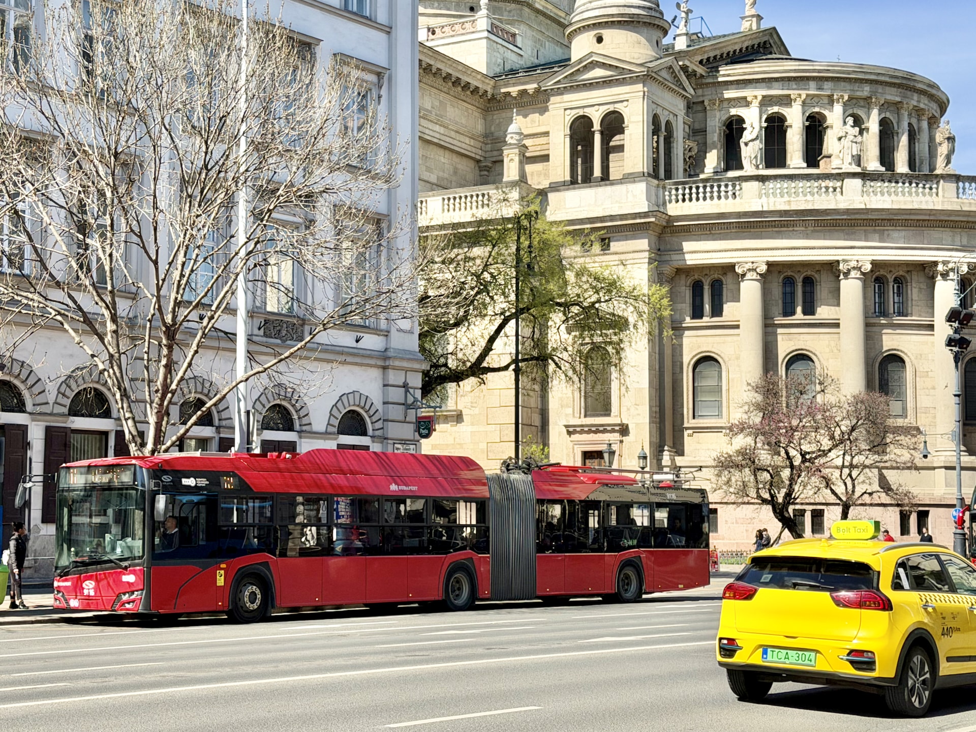 Trolleybus and Bolt taxi behind St. Stephen's Basilica.