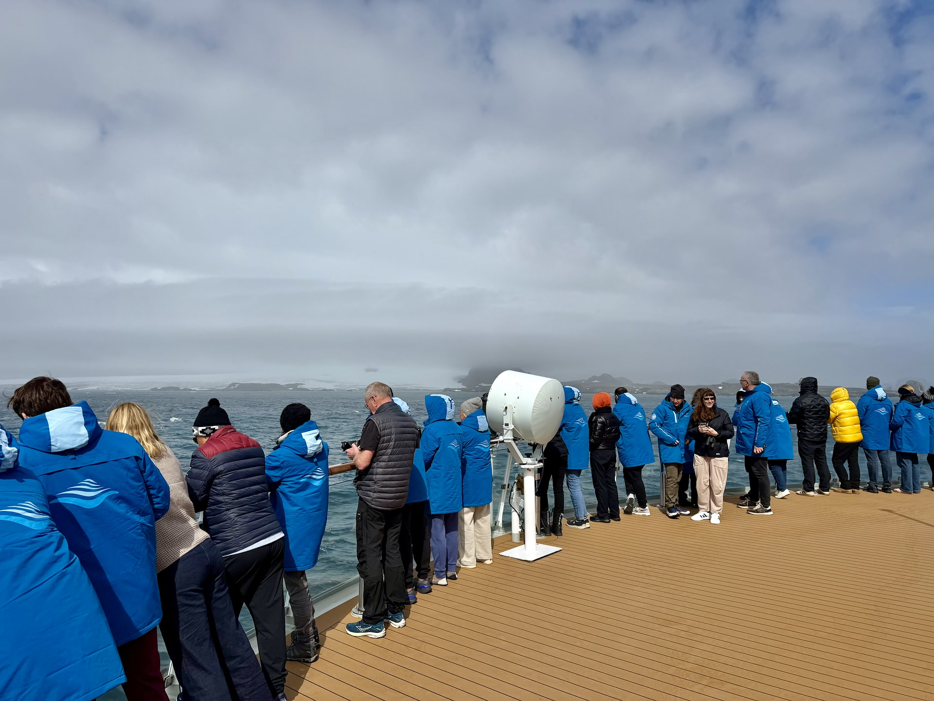 Cruise passengers gathered on the deck of the Ocean Albatros as the ship approaches Antarctica for the first time