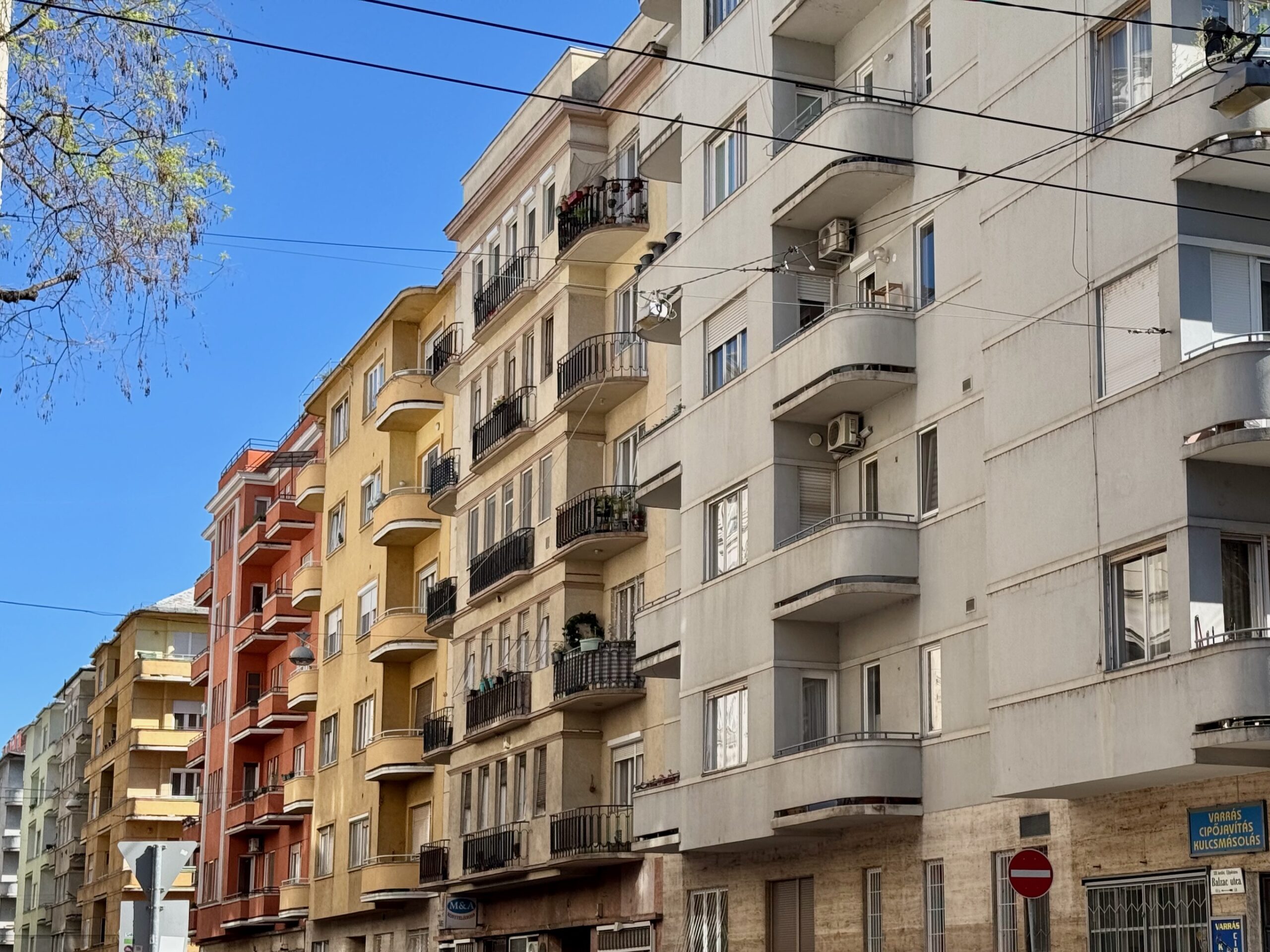 Row of colourful interwar apartment buildings on street in Budapest 13th district with rounded balconies
