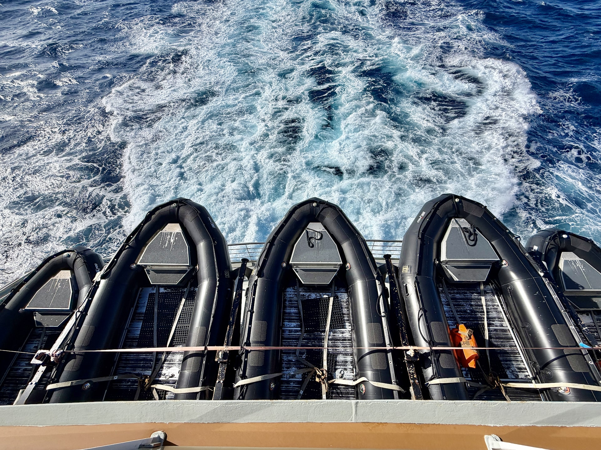 Zodiac inflatables stowed on the deck of the Ocean Albatros in morning sunshine after the last expedition landing