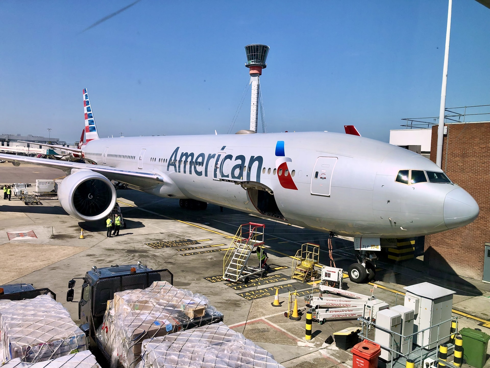 American Airlines Boeing 777 at London Heathrow Airport LHR American Airlines Boeing 777 at London Heathrow Airport gate with air traffic control tower in background