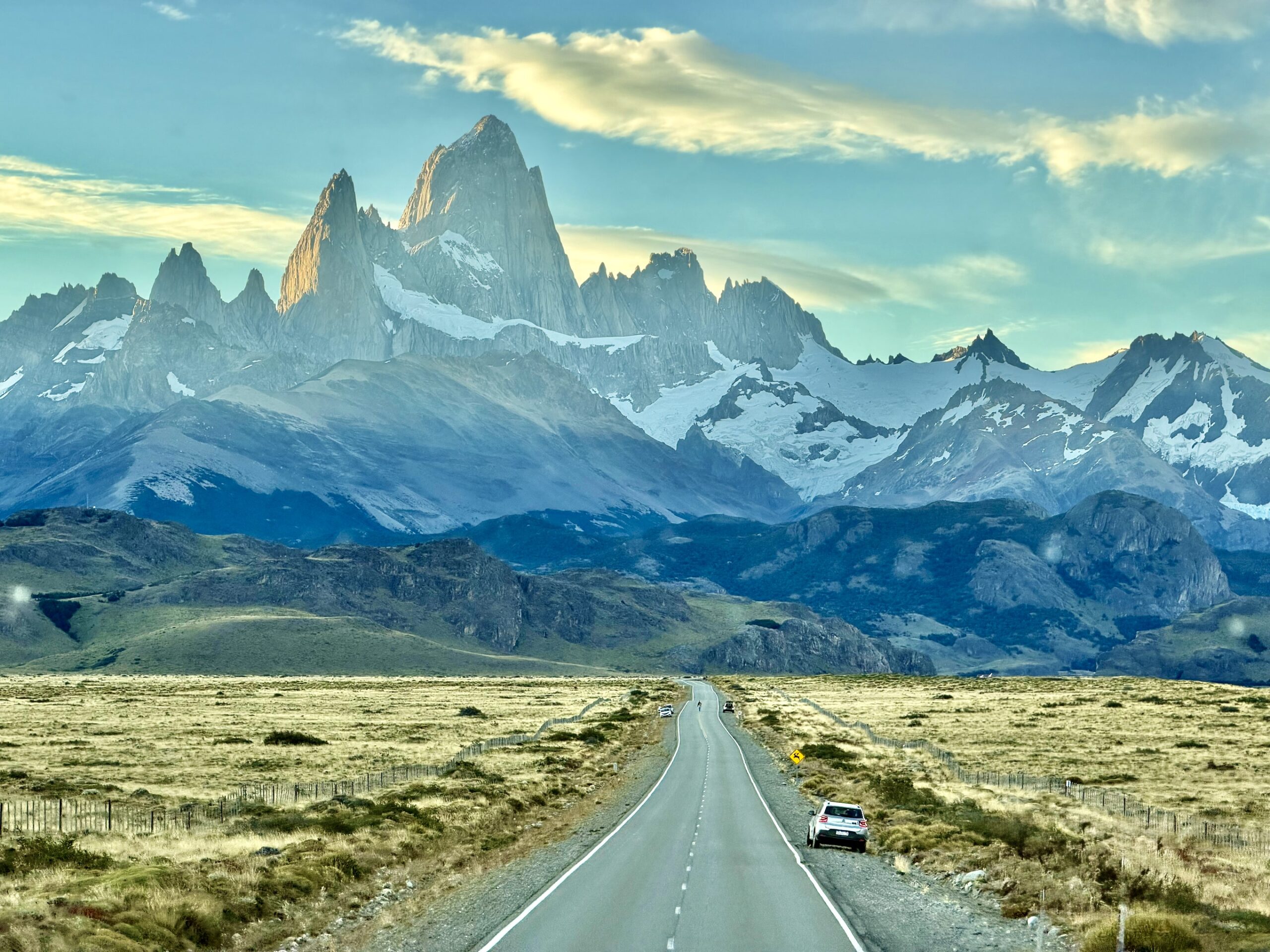 Straight road leading toward the Fitz Roy massif at dusk, Patagonian steppe on both sides near El Chaltén, Argentina