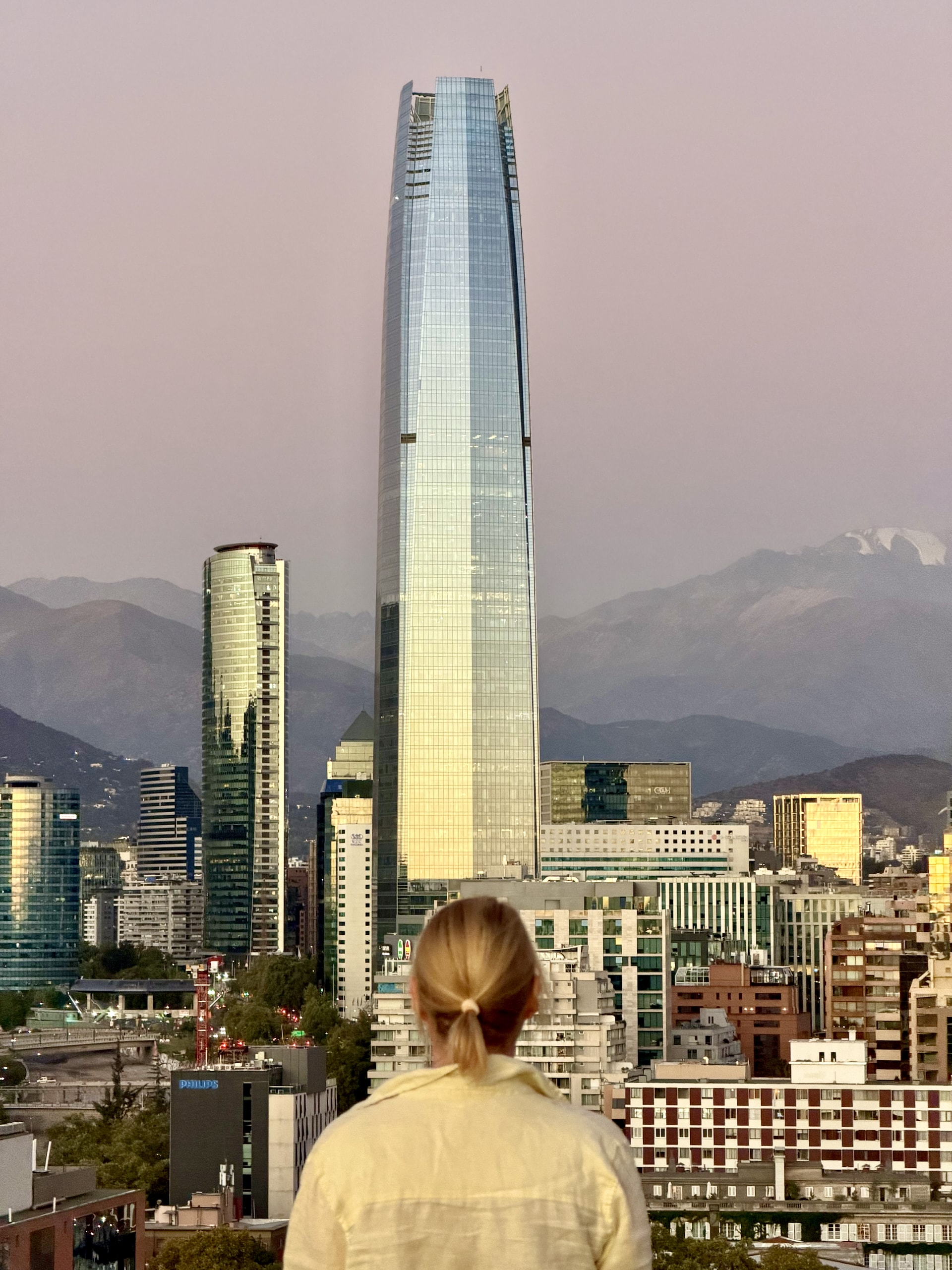 Rooftop view of Torre Costanera and Andes Santiago Chile Andrea looking toward the Torre Costanera skyscraper over the Santiago skyline from a rooftop at dusk, Andes mountains behind, Chile