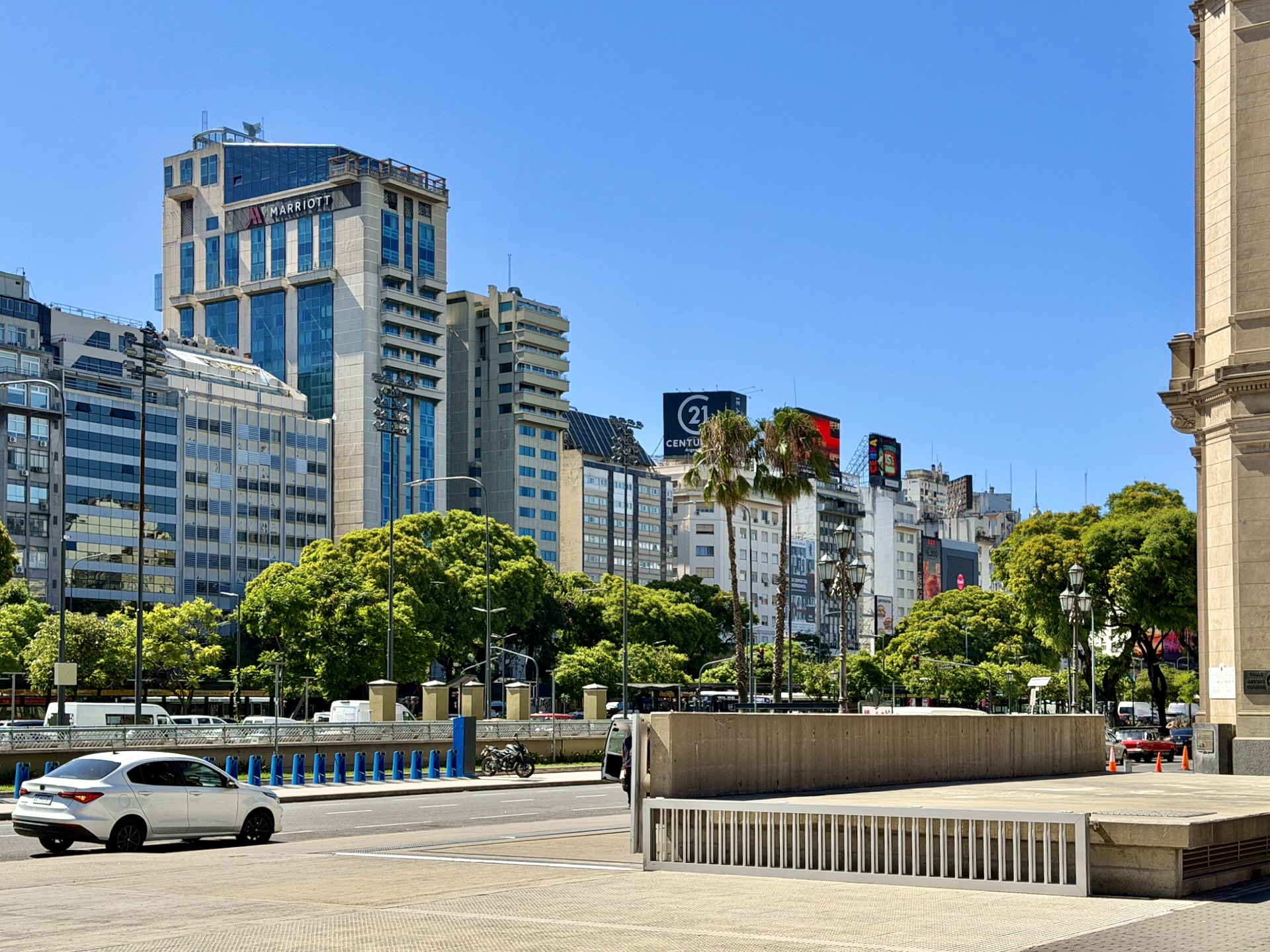 A wide view across Avenida 9 de Julio in Buenos Aires, with the Marriott tower and palm trees along the avenue.