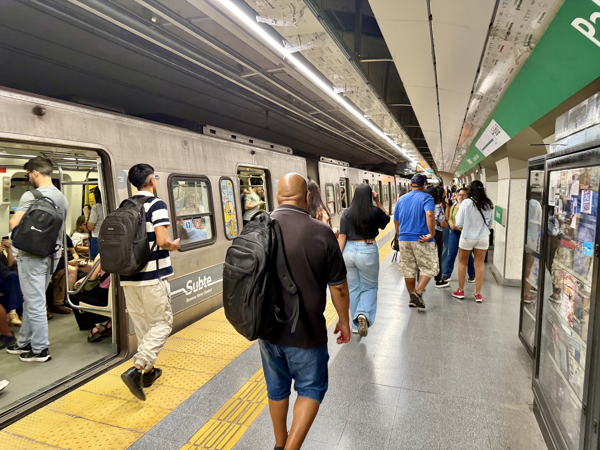 Passengers boarding a Subte train on a busy Buenos Aires underground platform.