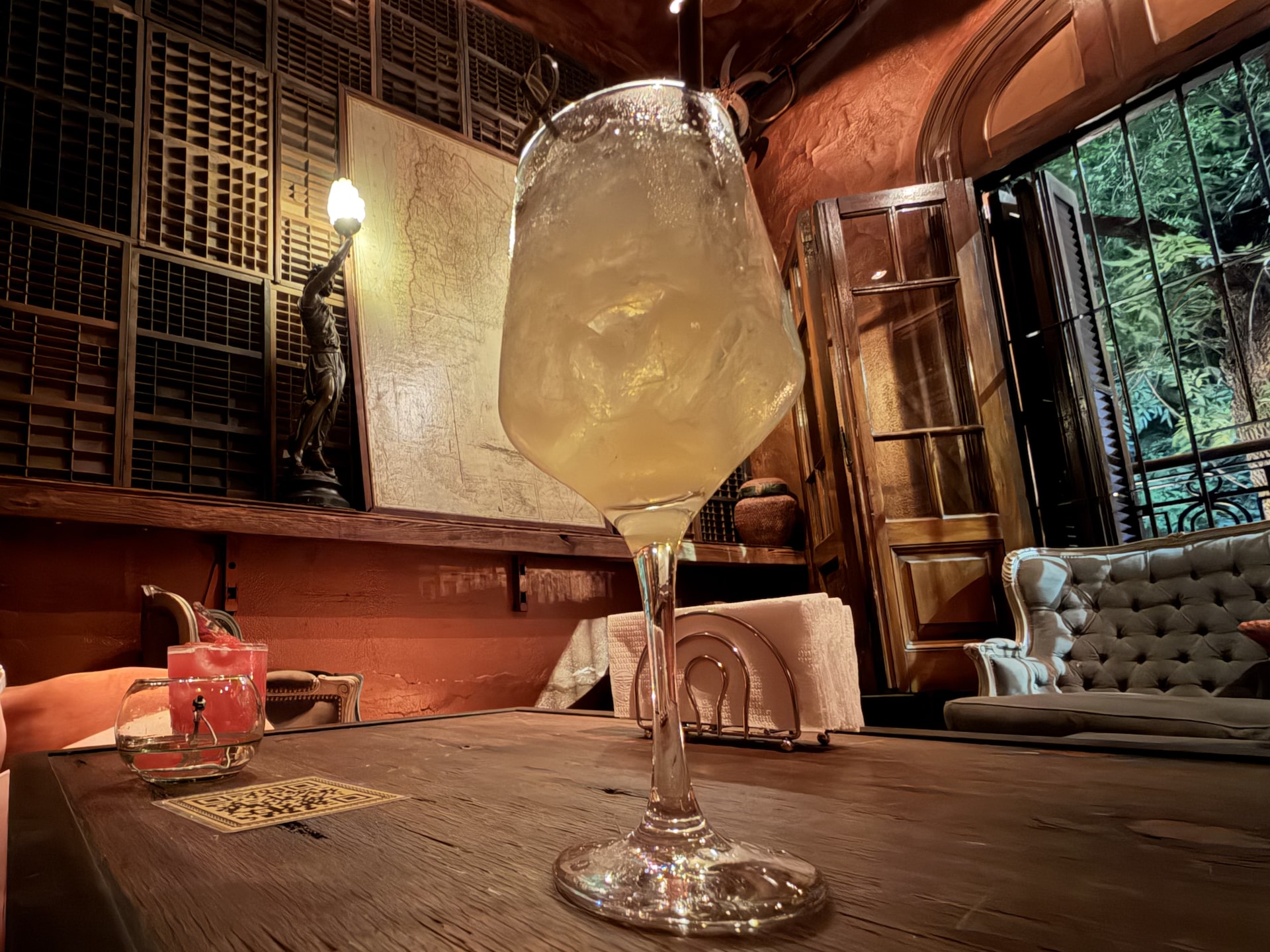A cocktail at Rey de Copas bar in Palermo A wine-glass cocktail on a wooden table inside the old-world interior of Rey de Copas bar in Buenos Aires.
