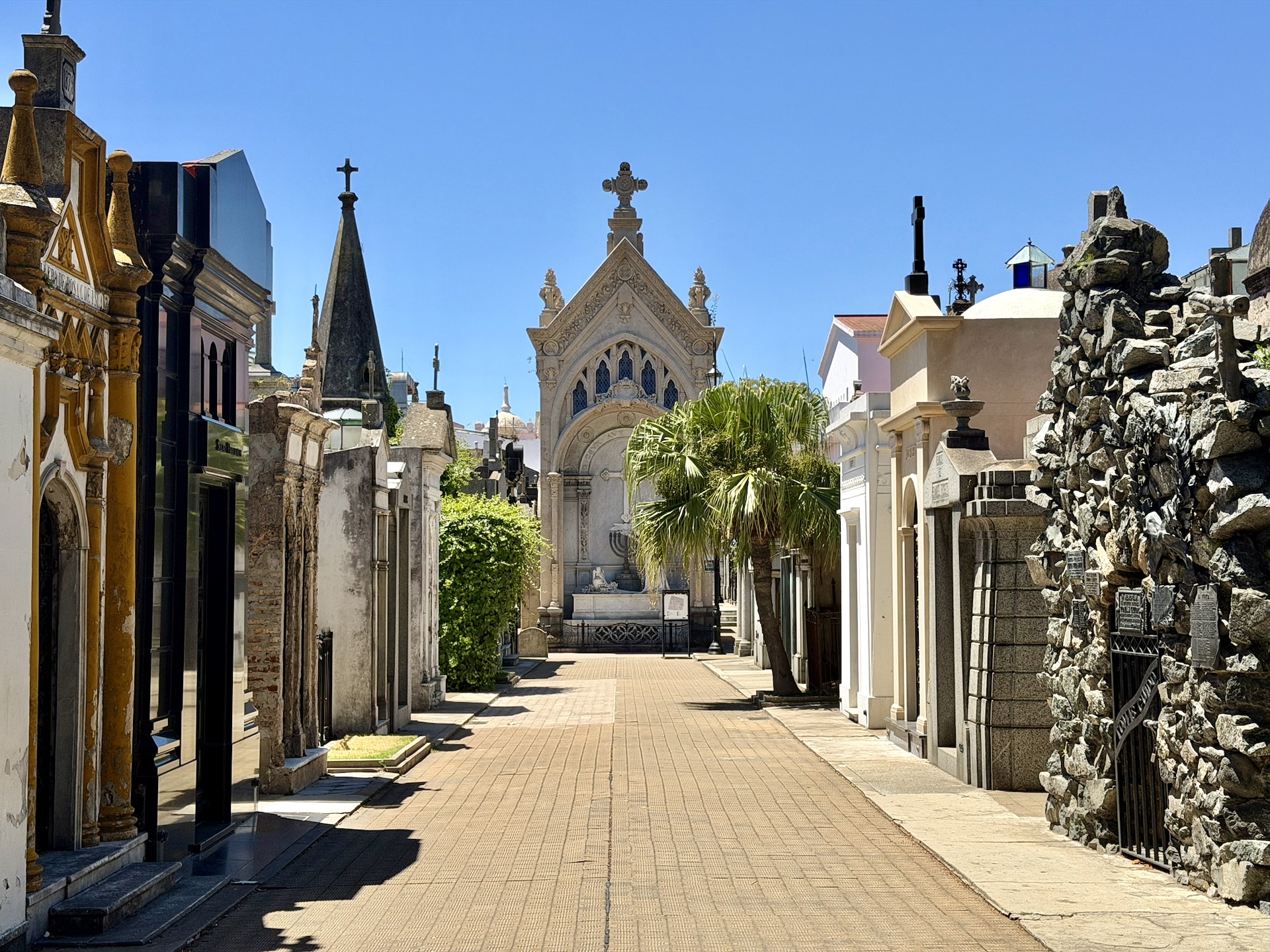A crypt-lined pathway in Recoleta Cemetery A narrow walkway lined with ornate stone crypts in Recoleta Cemetery, Buenos Aires.