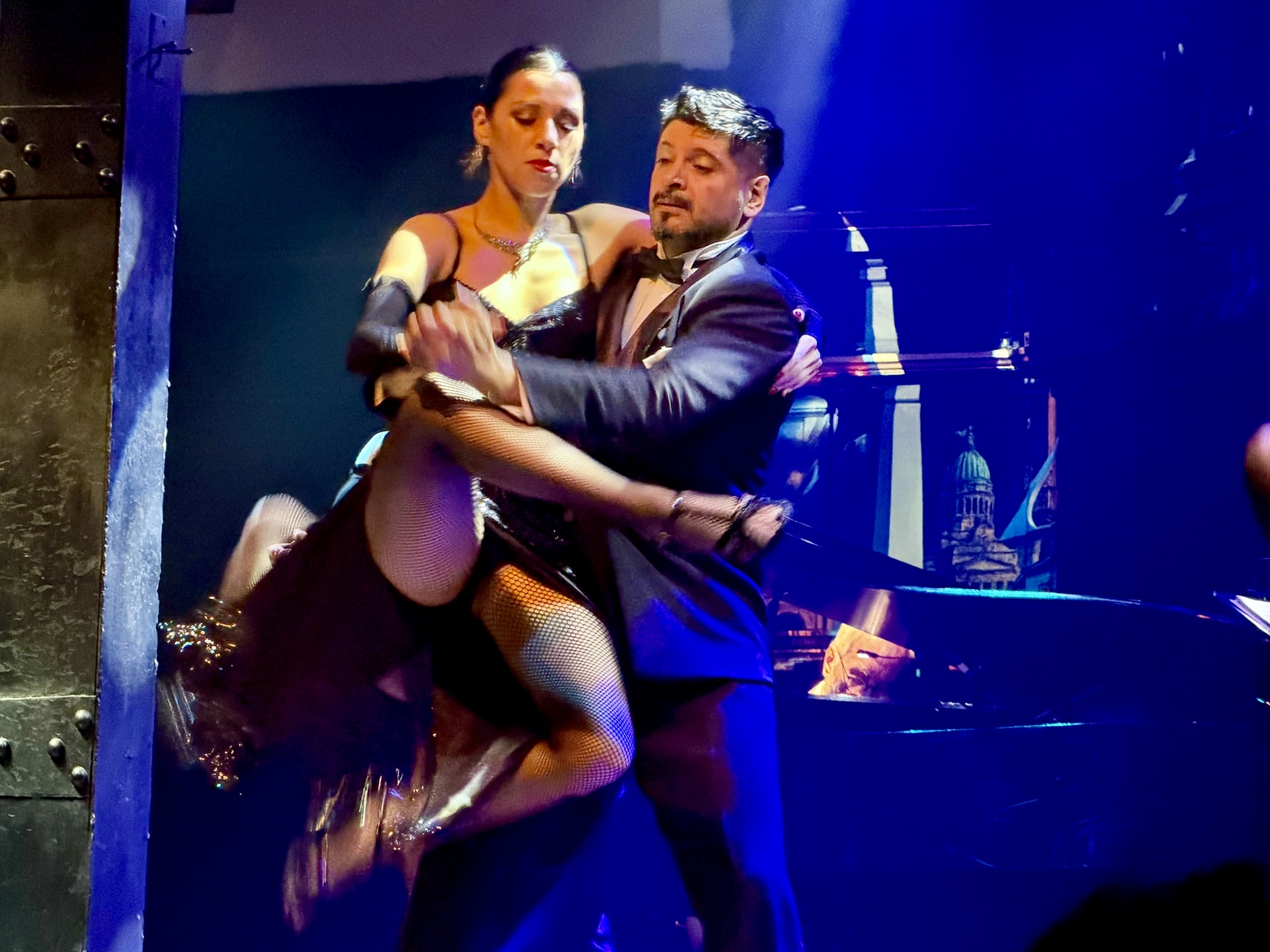 A demanding tango lift at the El Querandí show A tango dancer lifting his partner during a dramatic move at the El Querandí show in Buenos Aires.