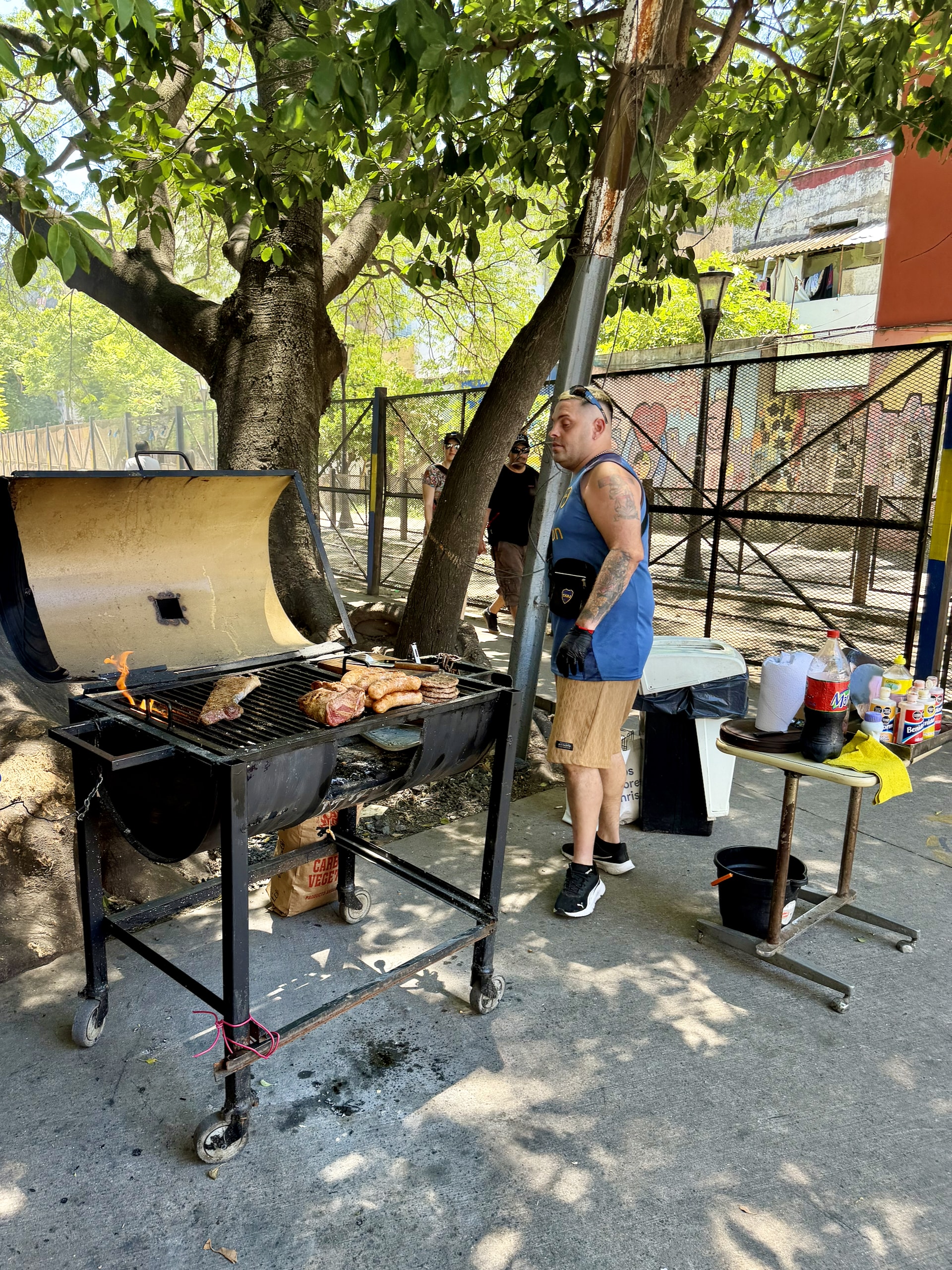 A roadside parrilla in La Boca, Buenos Aires A man grilling steak and sausages on an open roadside barbecue in La Boca, Buenos Aires.