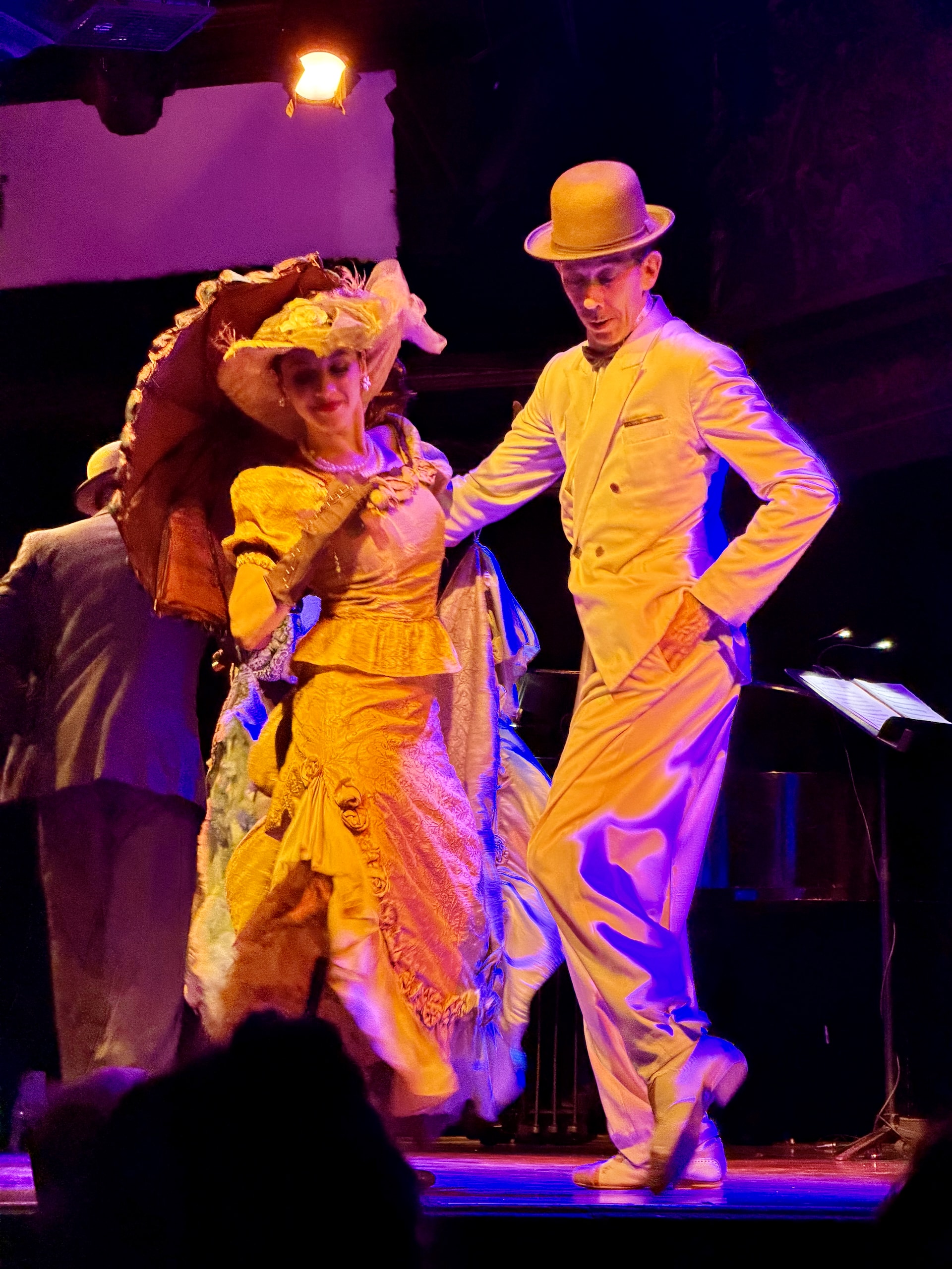 Early-style tango costumes at the El Querandí show Dancers at El Querandí in Belle Époque costume, the man in a bowler hat and the woman with a parasol, performing an early tango style.