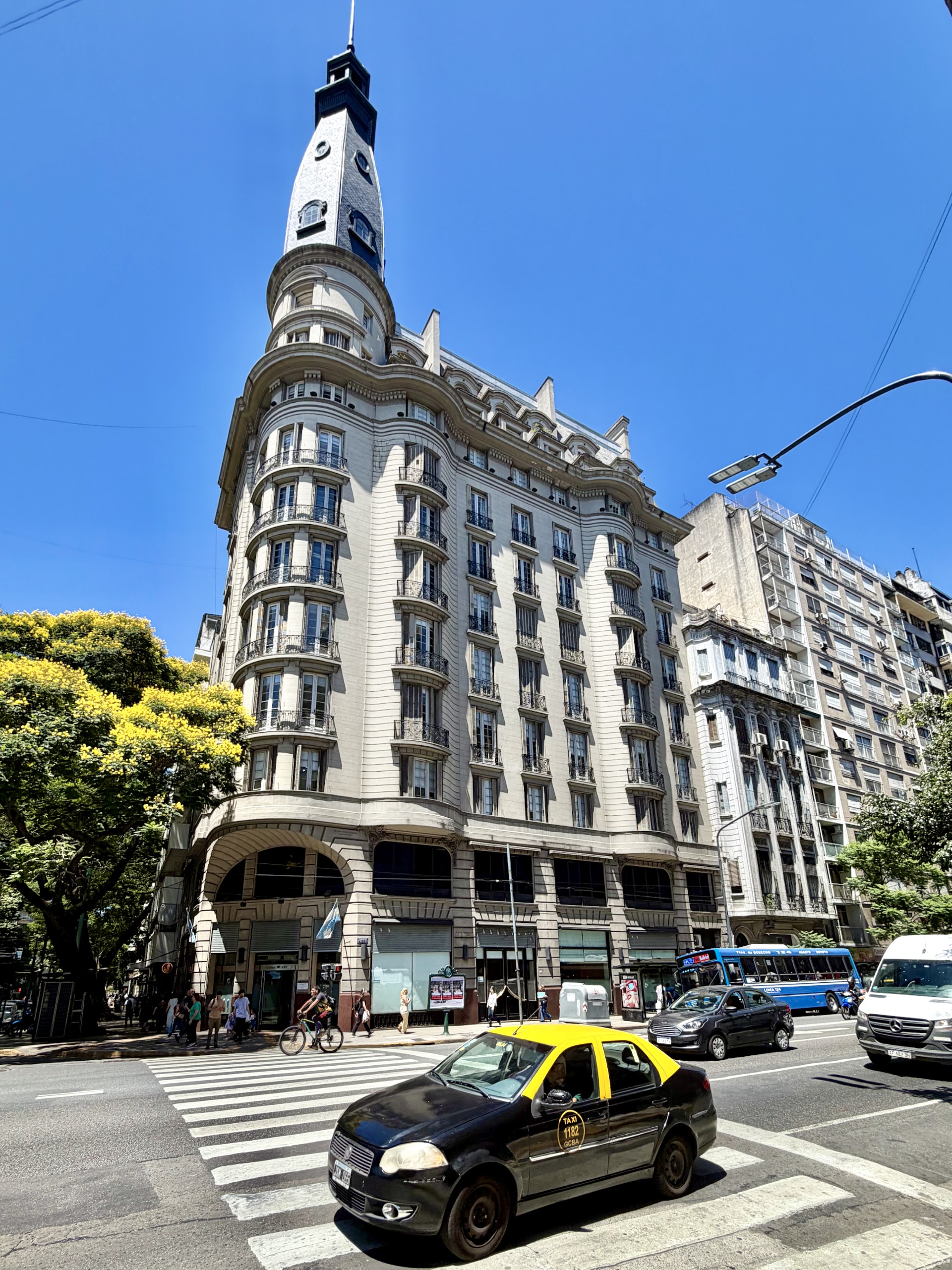 Ornate building on Avenida Callao with a classic Buenos Aires taxi An ornate Beaux-Arts corner building with a slate-topped turret on Avenida Callao, a black-and-yellow Buenos Aires taxi passing in front.
