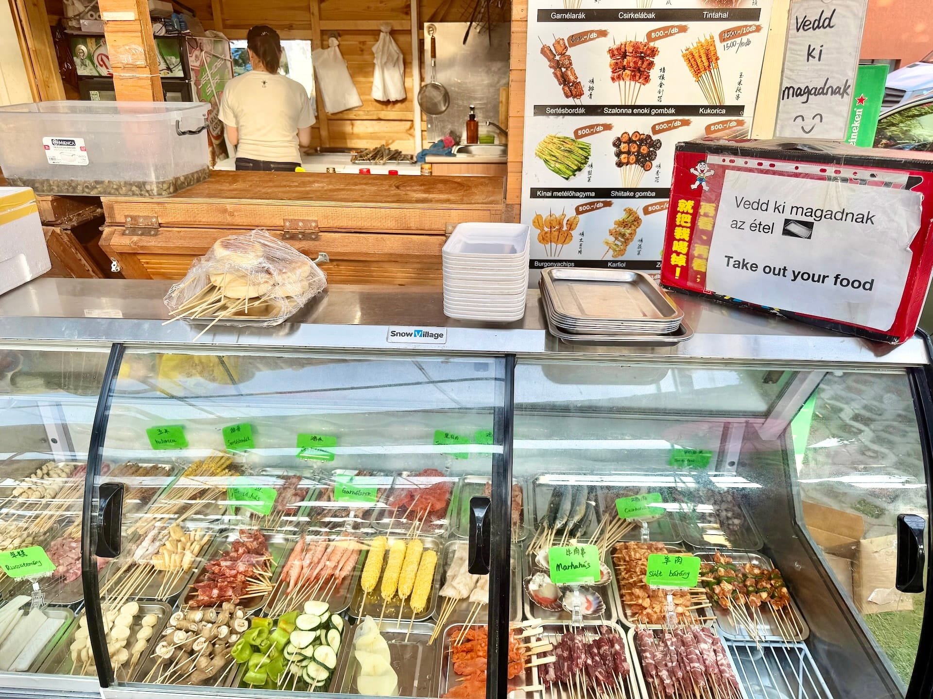 Pick your own skewer stall at Bian Garden Budapest Refrigerated display case of raw skewers at Bian Garden, with a sign reading Take out your food