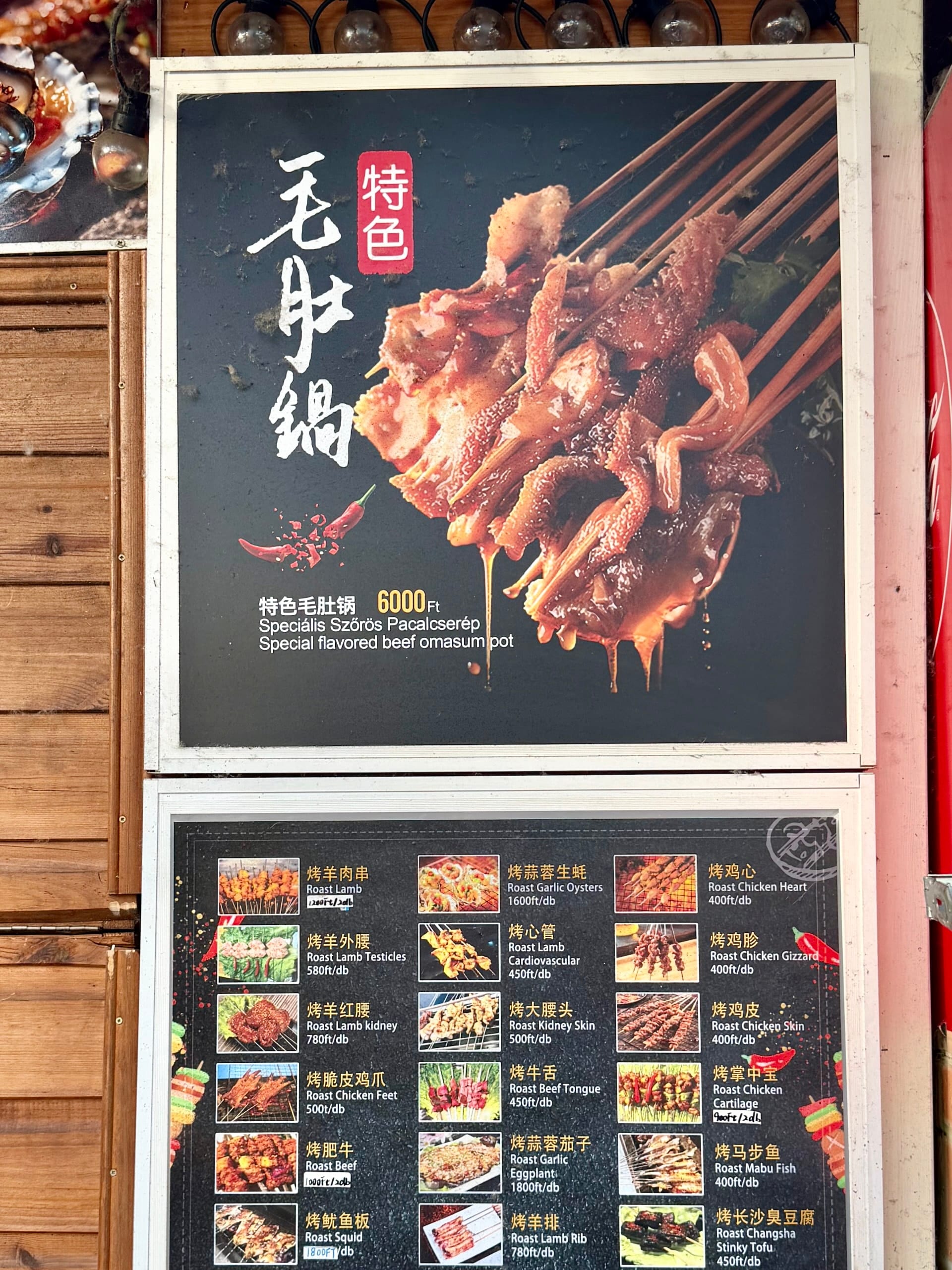 Special flavored beef omasum pot sign at Bian Garden Menu board advertising a special flavored beef omasum pot for 6,000 HUF above a board of roast skewers