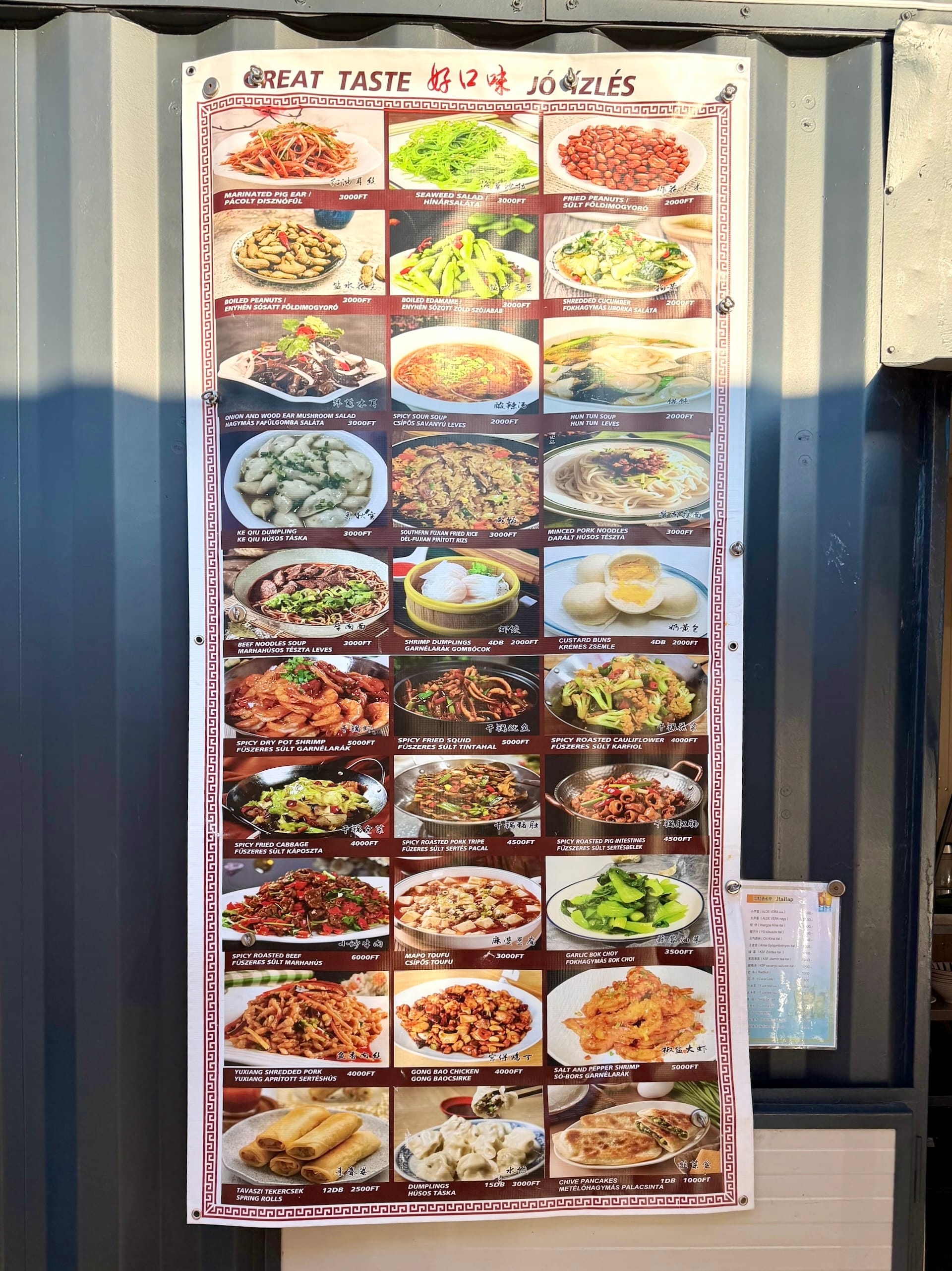 Chinese menu board with pig ear and intestines at Fully Night Market Chinese menu board headed Great Taste at Fully Night Market, listing marinated pig ear, roasted pig intestines and pork tripe.