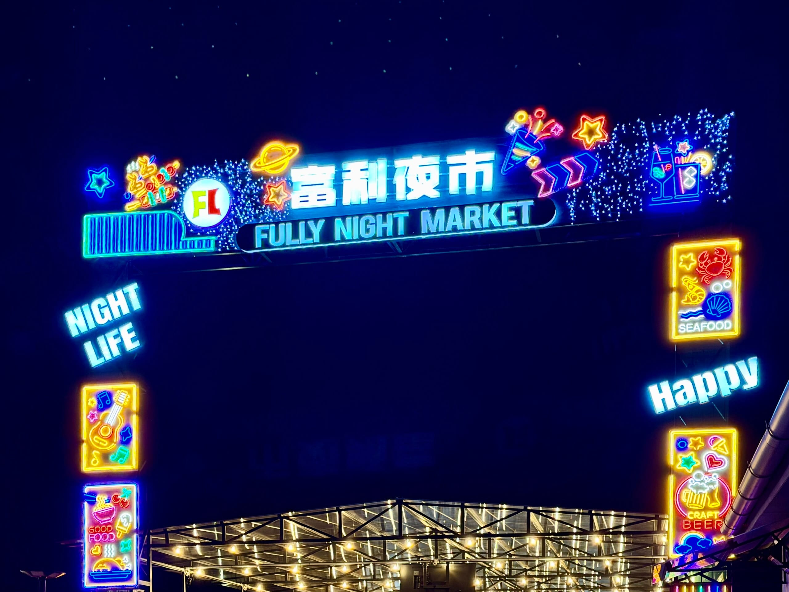 The illuminated Fully Night Market sign in Budapest at night, with the Chinese name in neon above the English one.