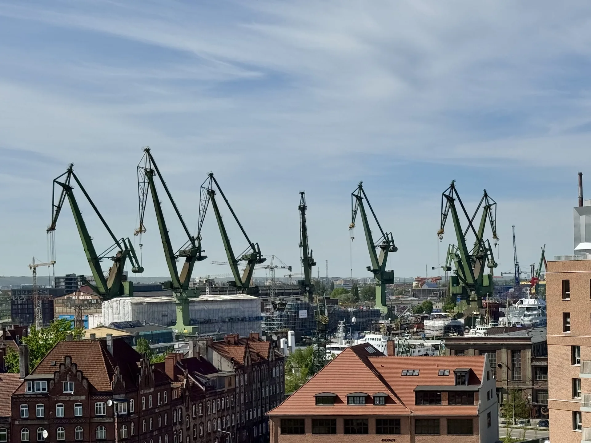 View from the European Solidarity Centre rooftop terrace over the cranes and warehouses of the old Gdańsk Shipyard.