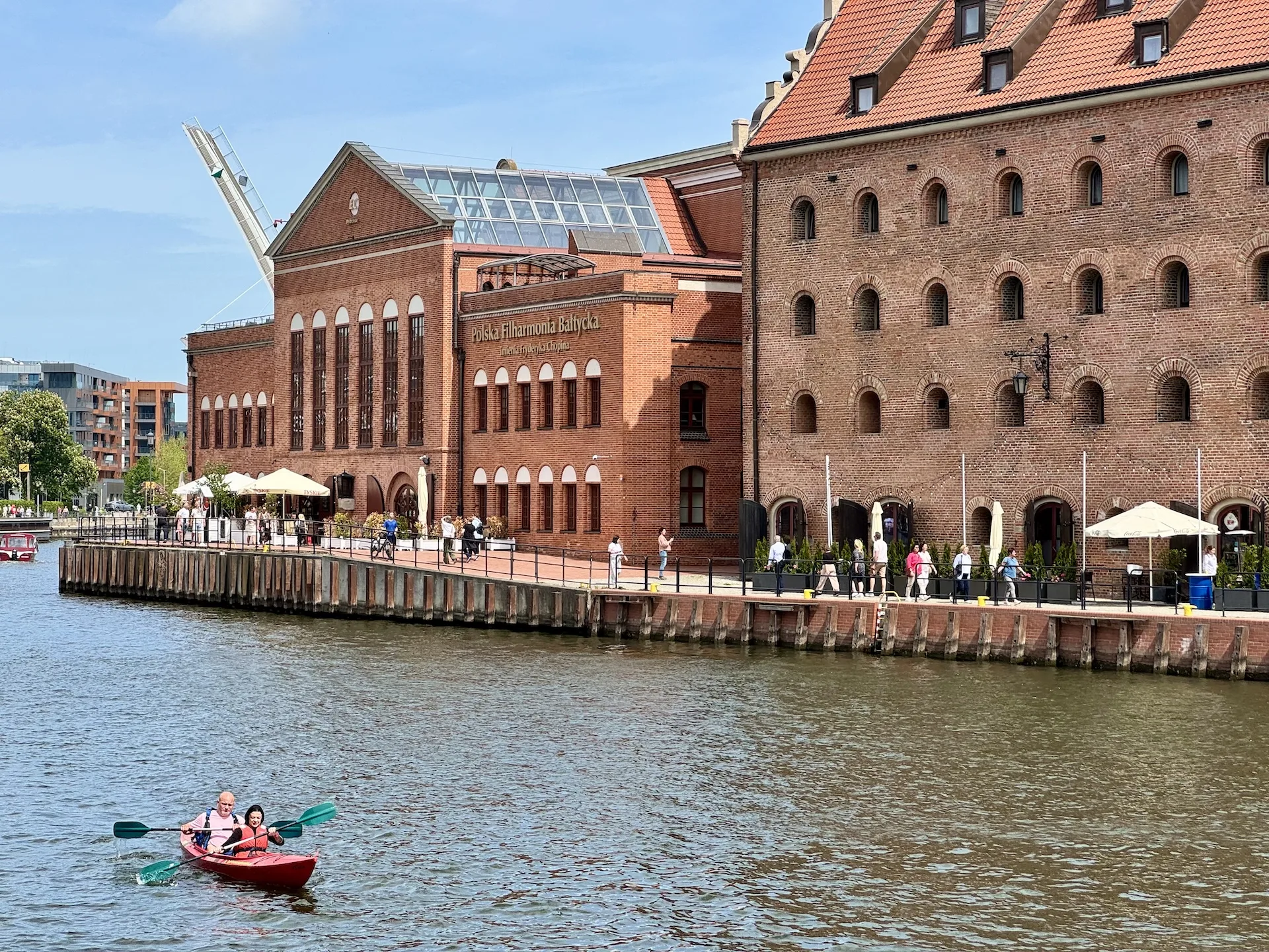 Kayakers on the Motława river in Gdańsk, passing the Polish Baltic Philharmonic on Ołowianka island.
