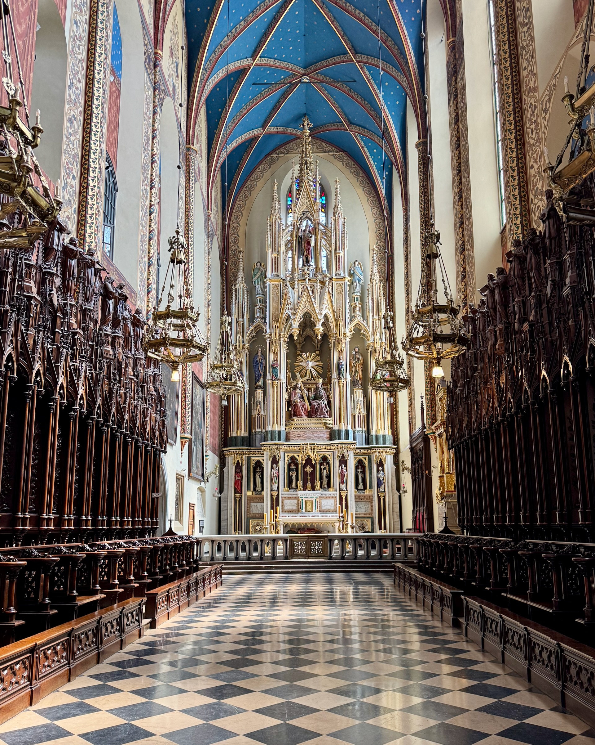 Deep blue star-studded Gothic vault above a gilded altar, the Franciscan Basilica in Krakow