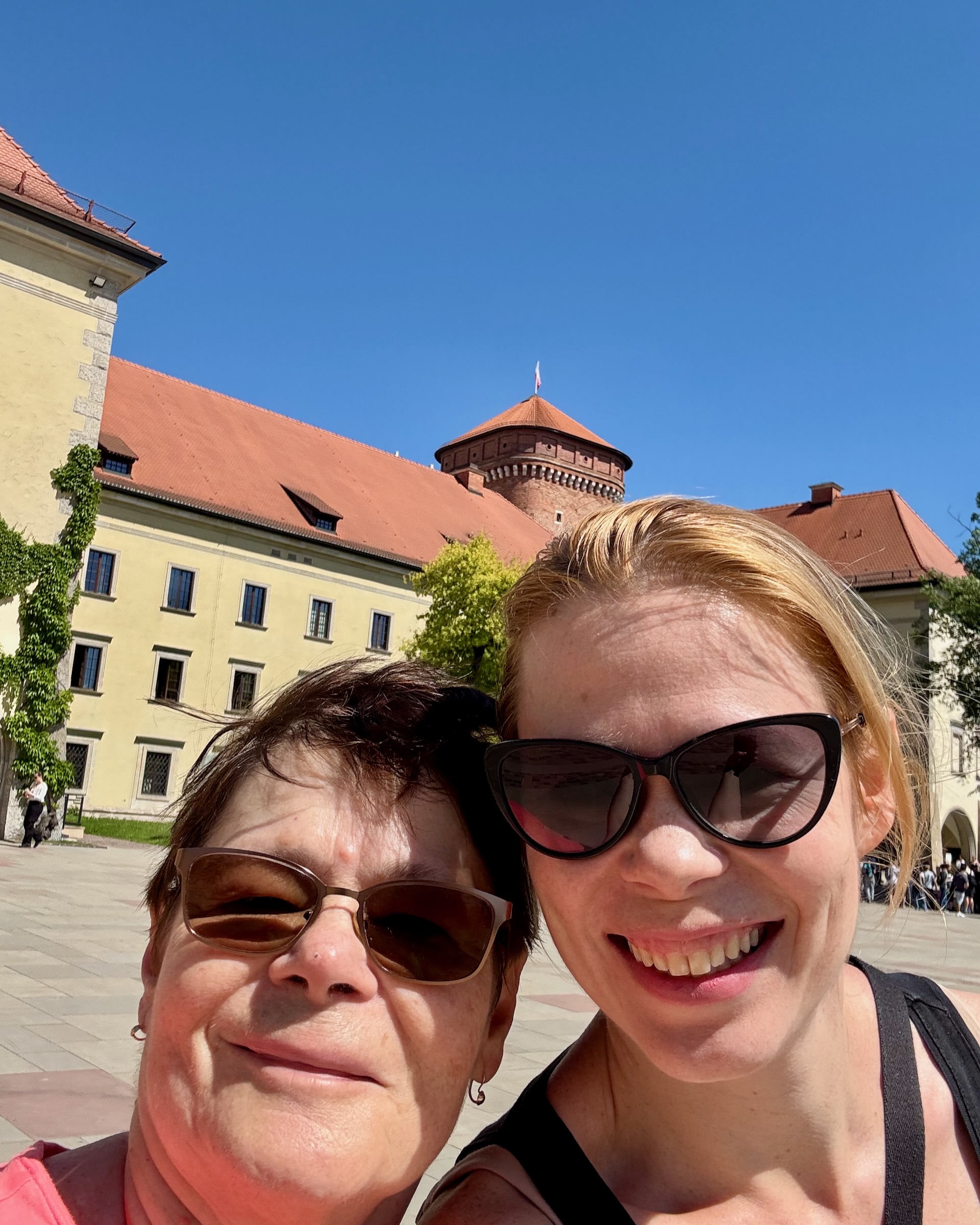 Andrea and her mother taking a selfie in the Wawel courtyard, castle tower behind them
