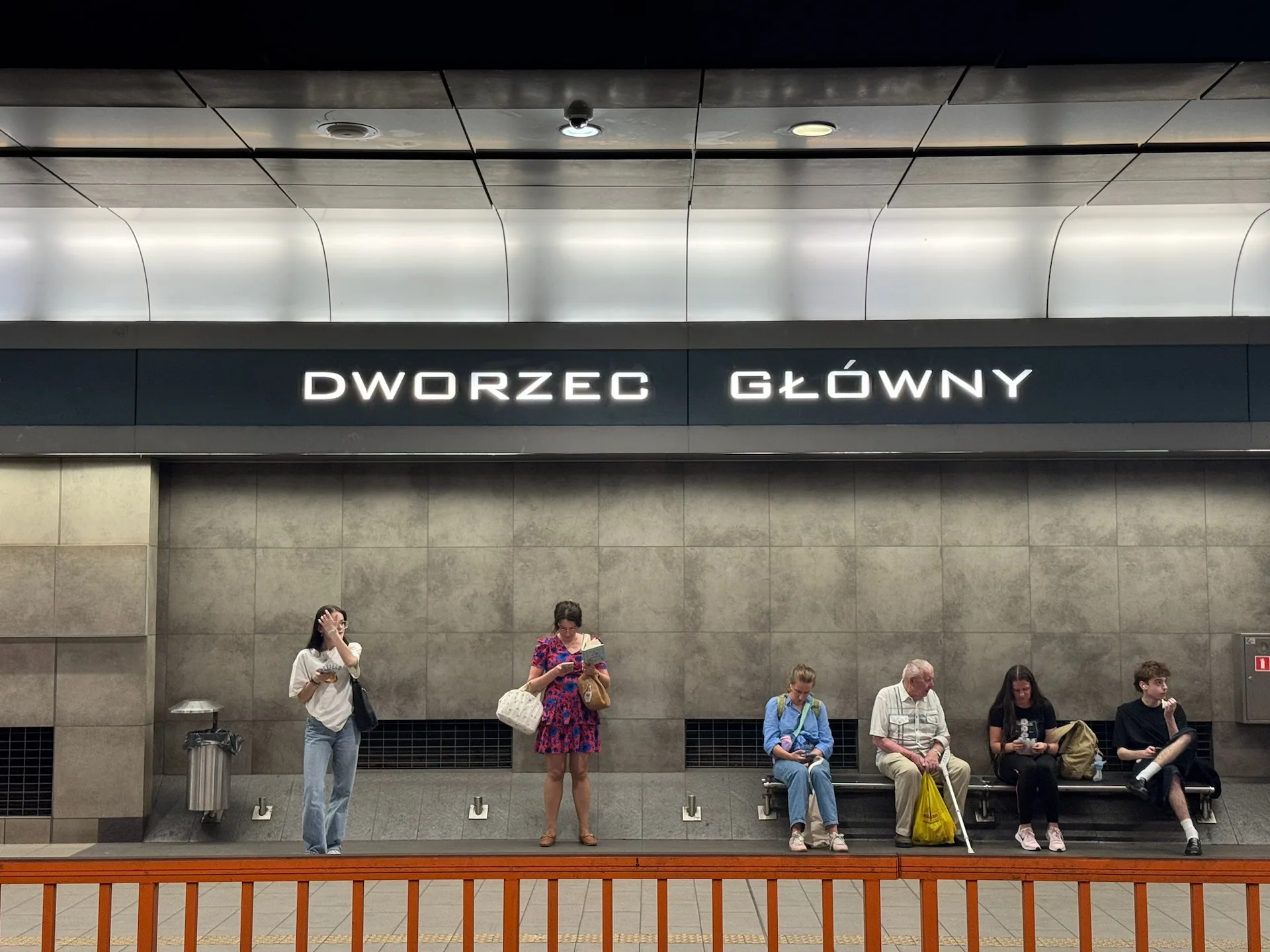 Kraków Główny station platform, SKA1 airport train arrival Passengers waiting on the underground platform at Kraków Główny station, marked "Dworzec Główny"