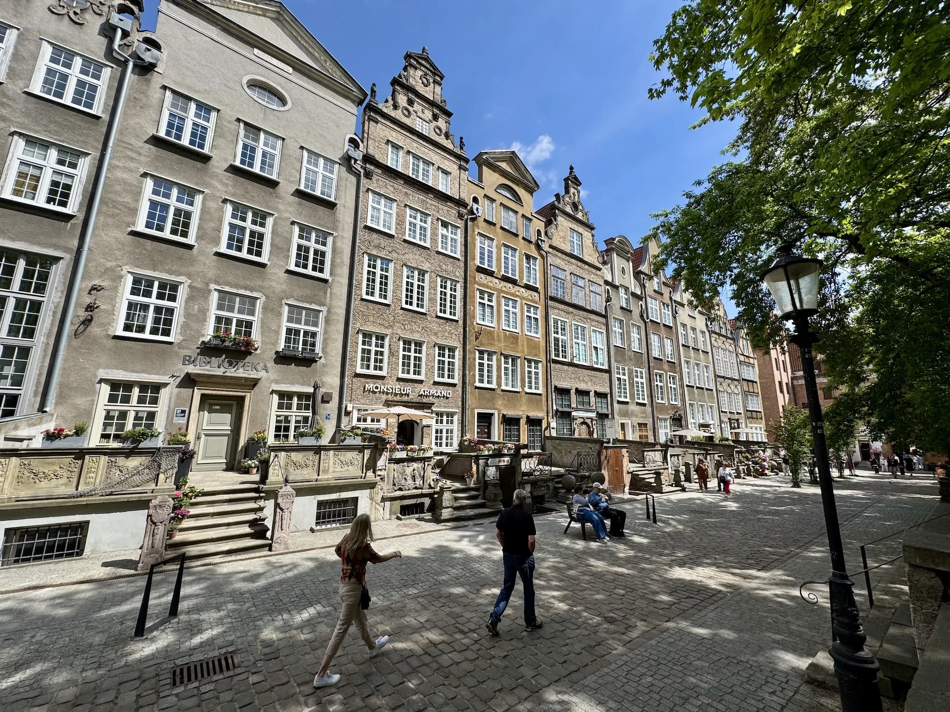 Rebuilt townhouses on Ulica Mariacka in Gdańsk, with terraced stone stoops and amber galleries at street level.