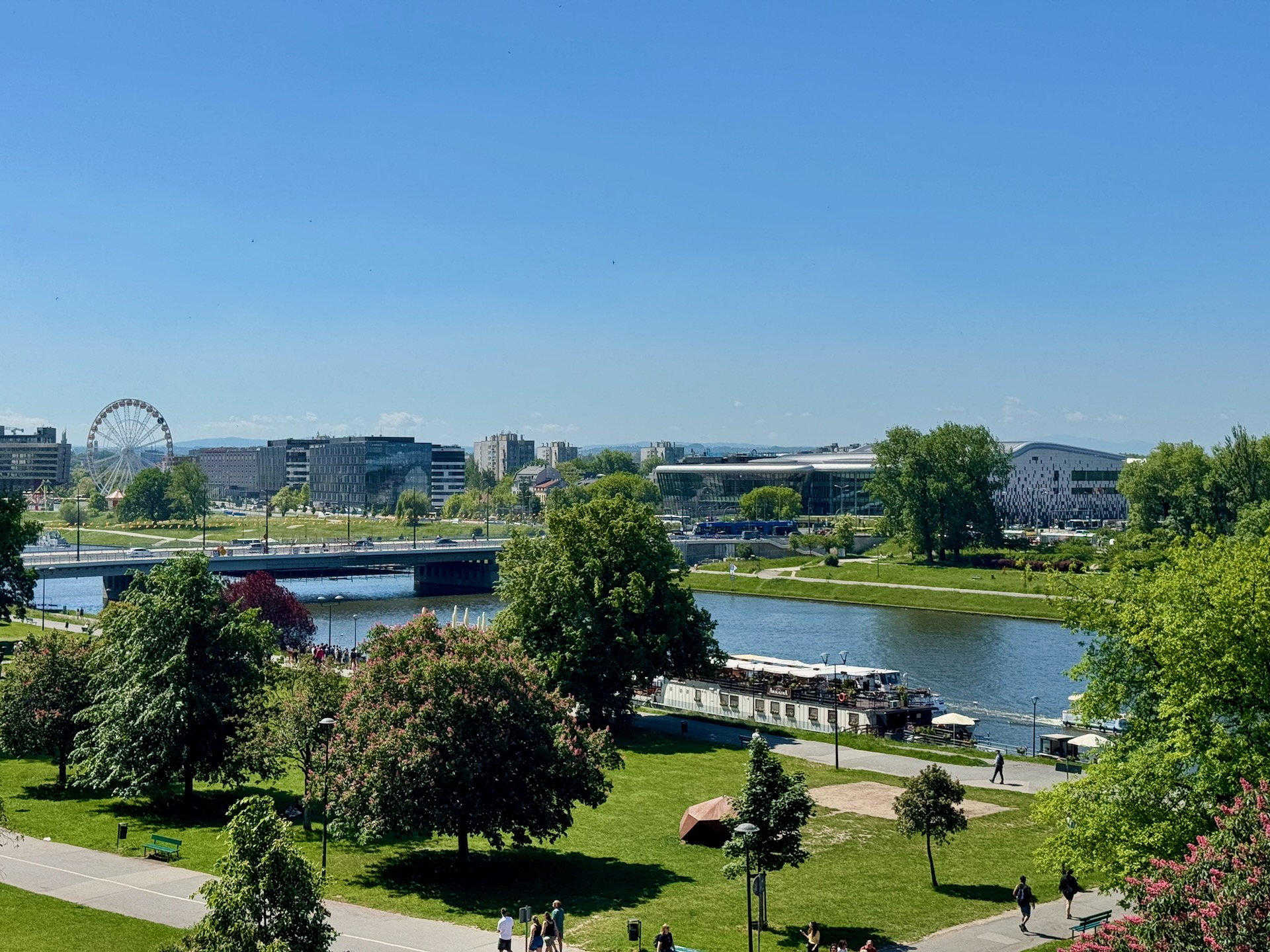 View from Wawel Hill over the Vistula River, with a Ferris wheel and bridge in the distance