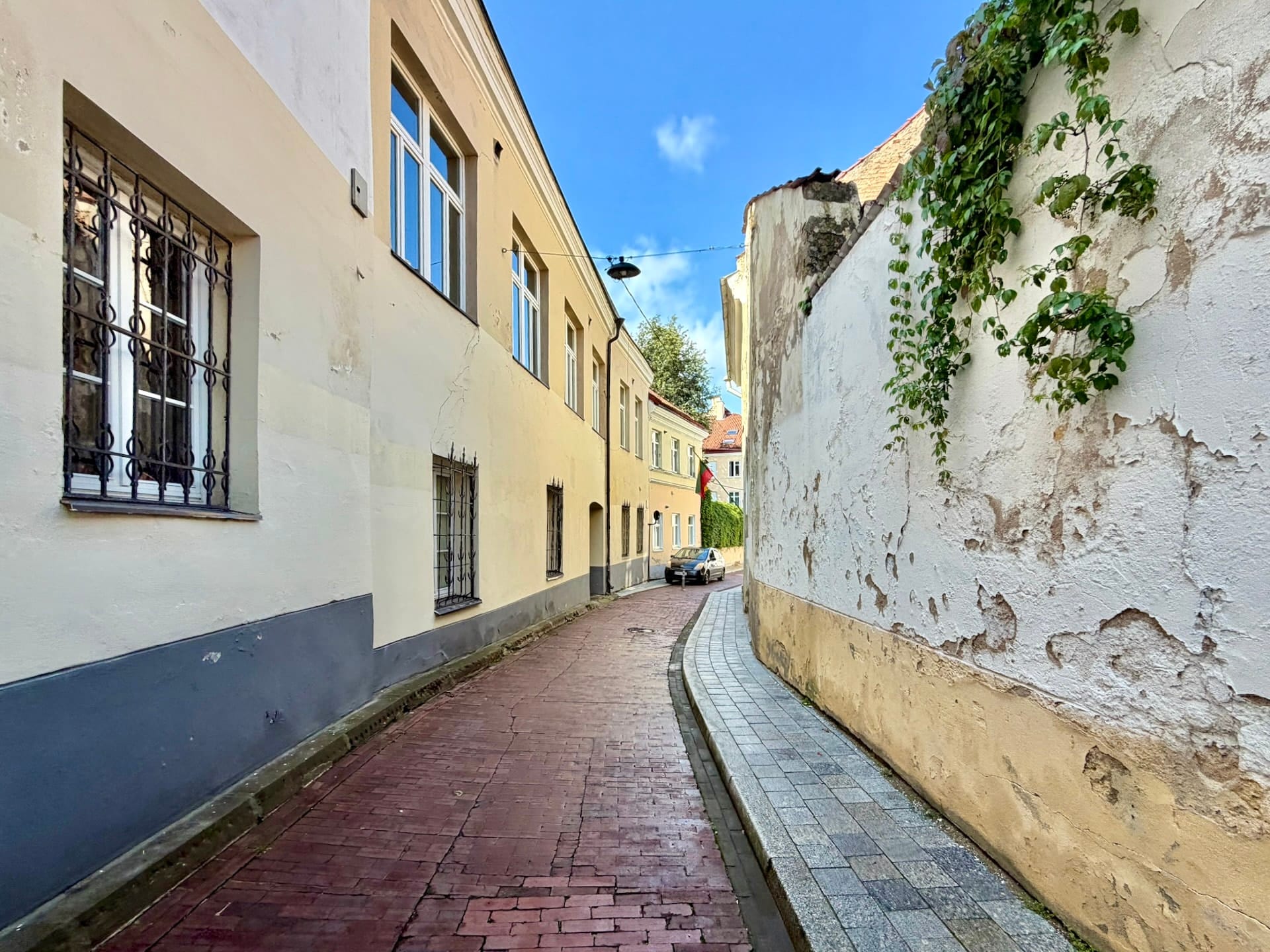 Narrow lane in Vilnius Old Town A narrow curving lane in Vilnius Old Town, red brick paving running between rendered walls.