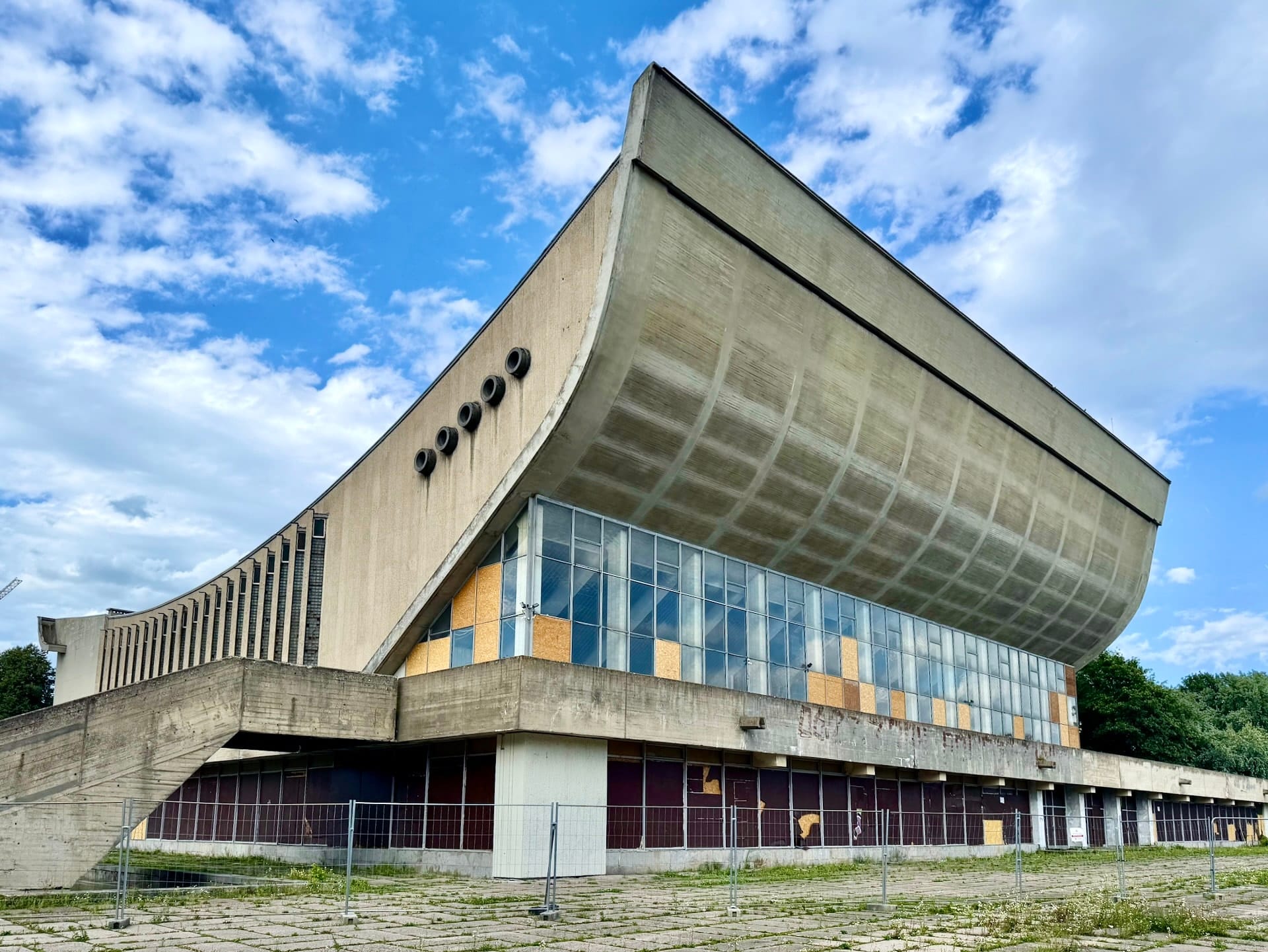 Palace of Concerts and Sports, the Sporto rūmai, Vilnius The derelict Palace of Concerts and Sports in Vilnius, its cantilevered concrete roof above boarded windows and security fencing.