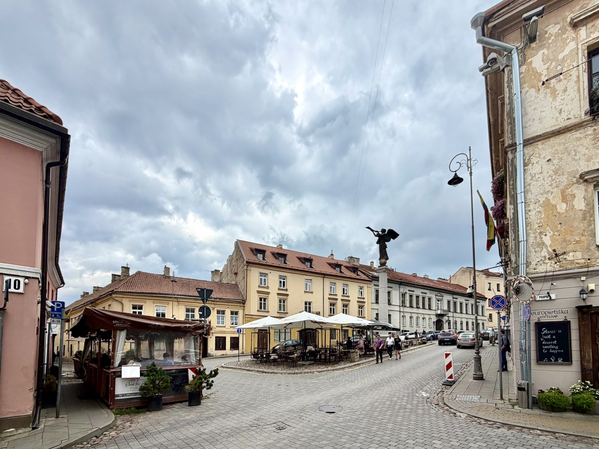 The main square of Užupis with the Angel The main square of Užupis in Vilnius, the bronze Angel on its column above pastel buildings and café terraces.