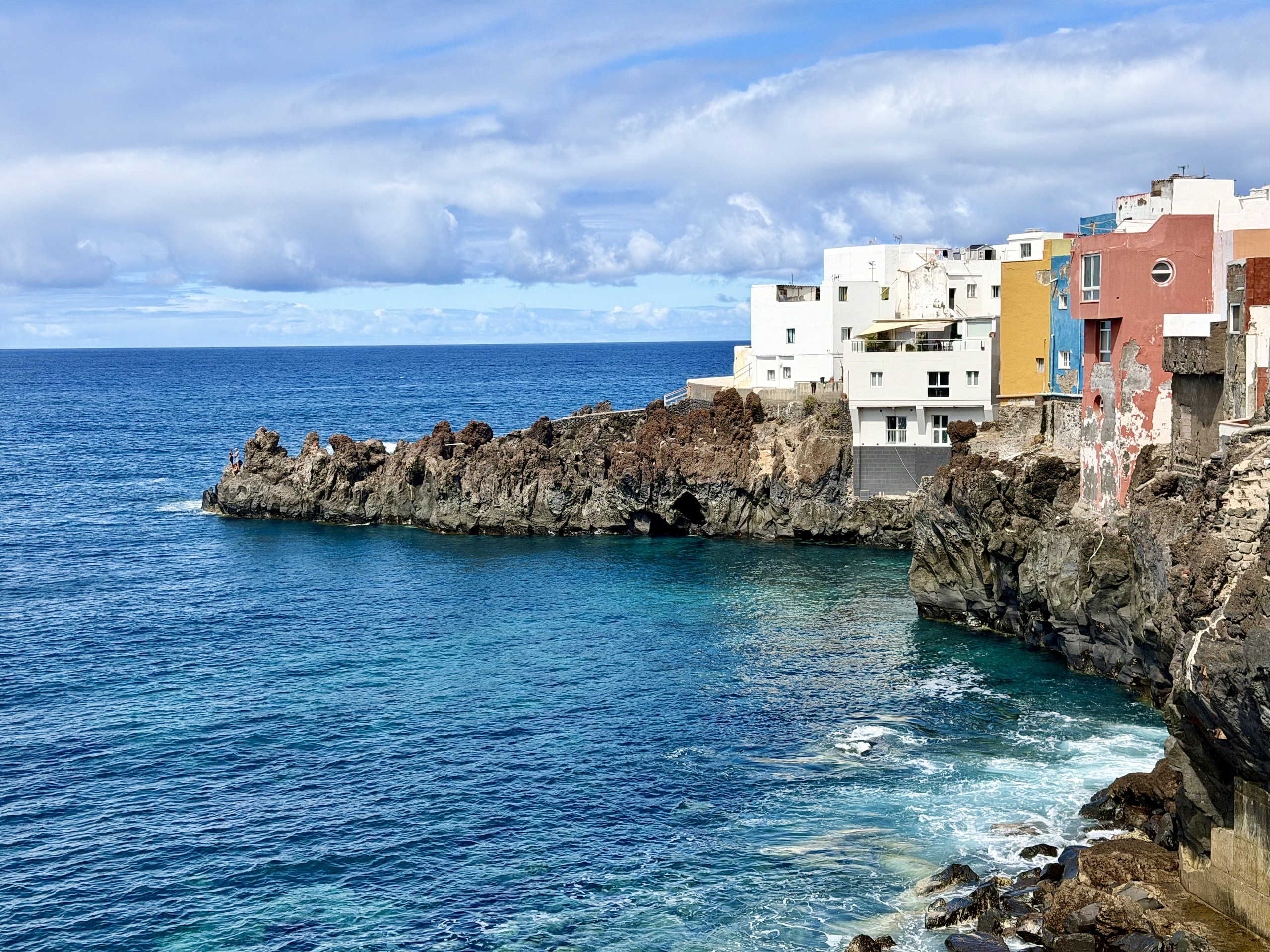 Colorful houses on a black lava headland above the deep blue Atlantic at Punta Brava, Puerto de la Cruz