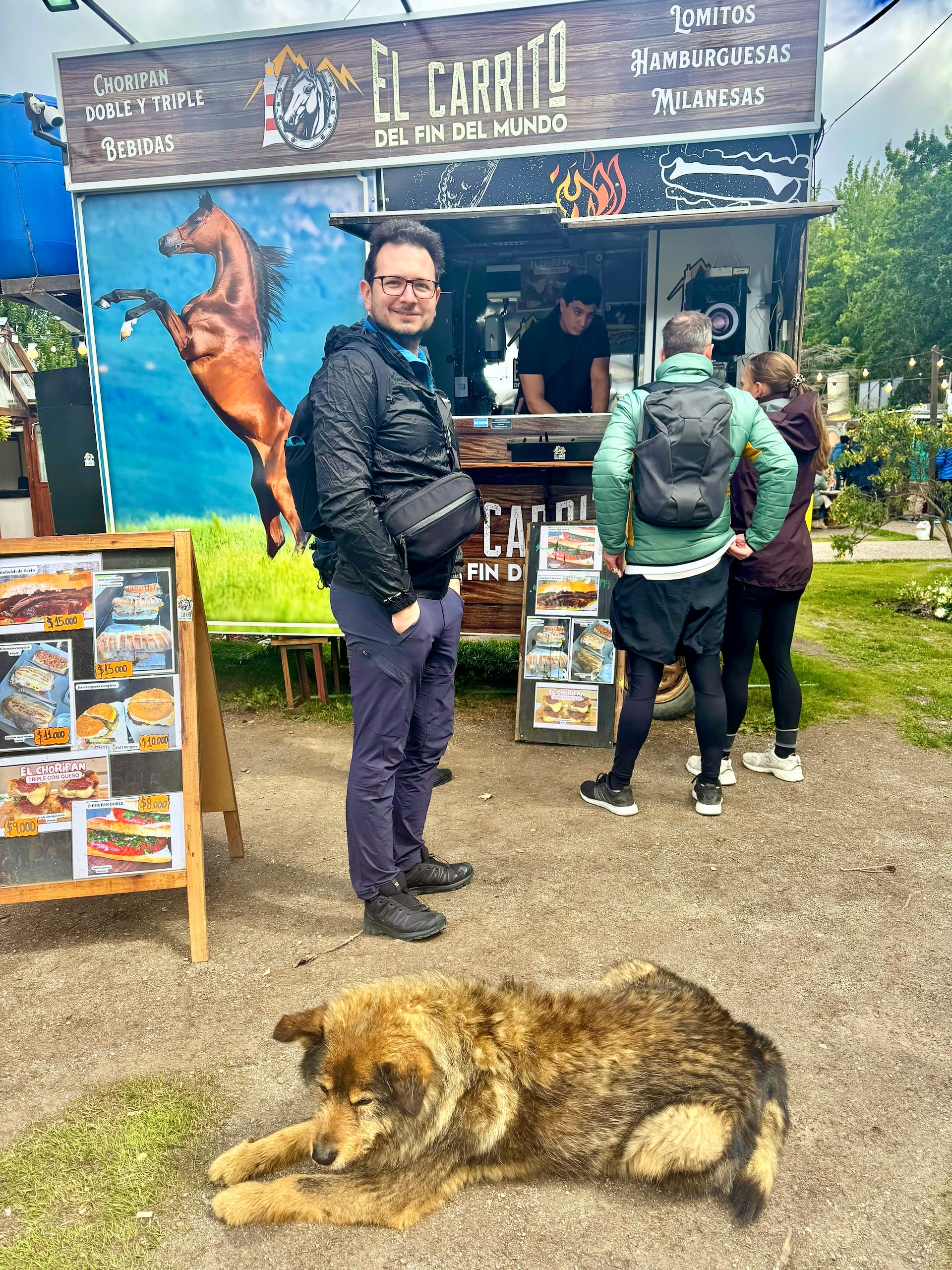 Laszlo queuing at the El Carrito del Fin del Mundo food truck in Ushuaia, a dog asleep in front