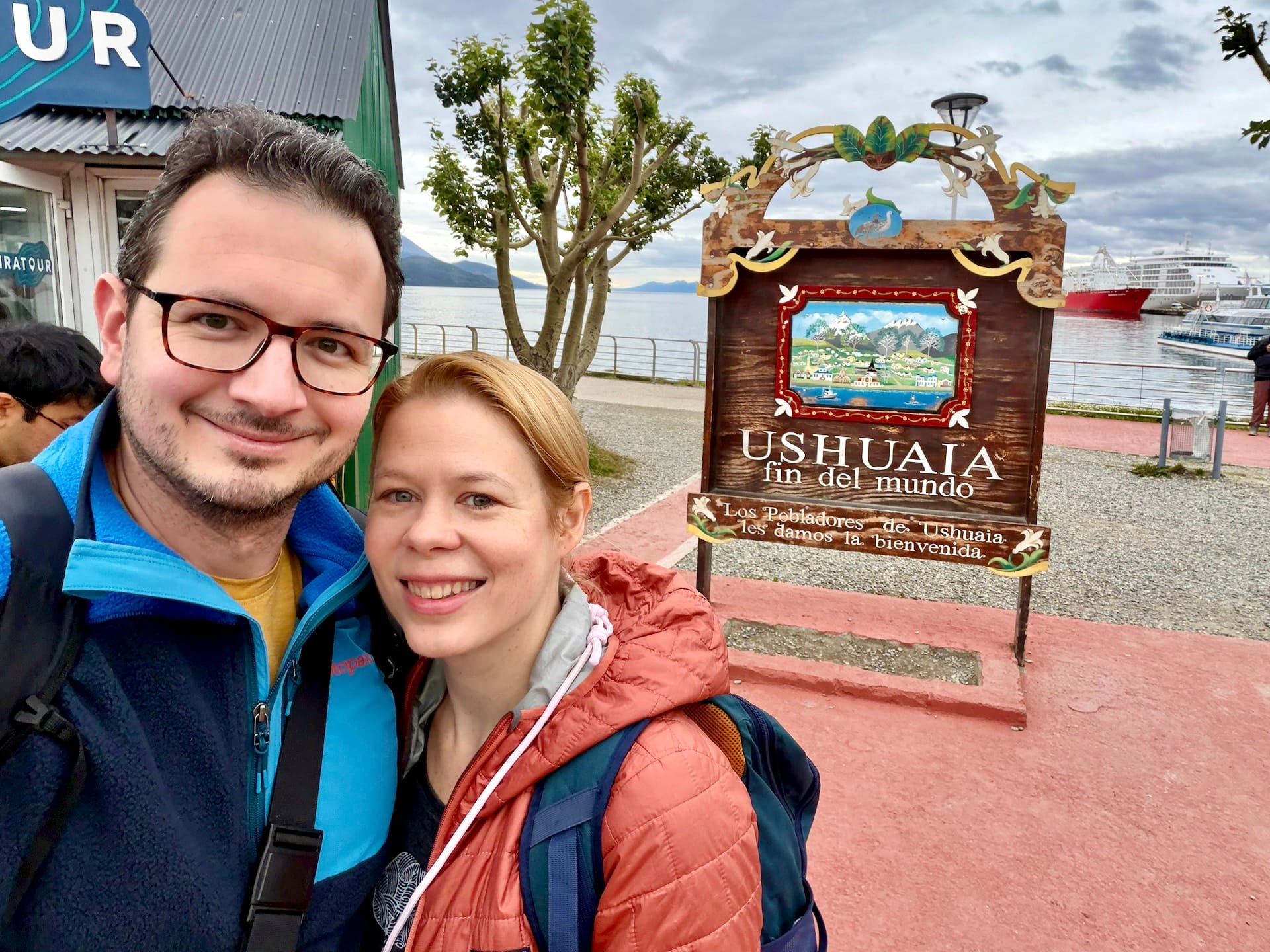Laszlo and Andrea taking a selfie at the wooden "Ushuaia fin del mundo" sign near the tourist information center